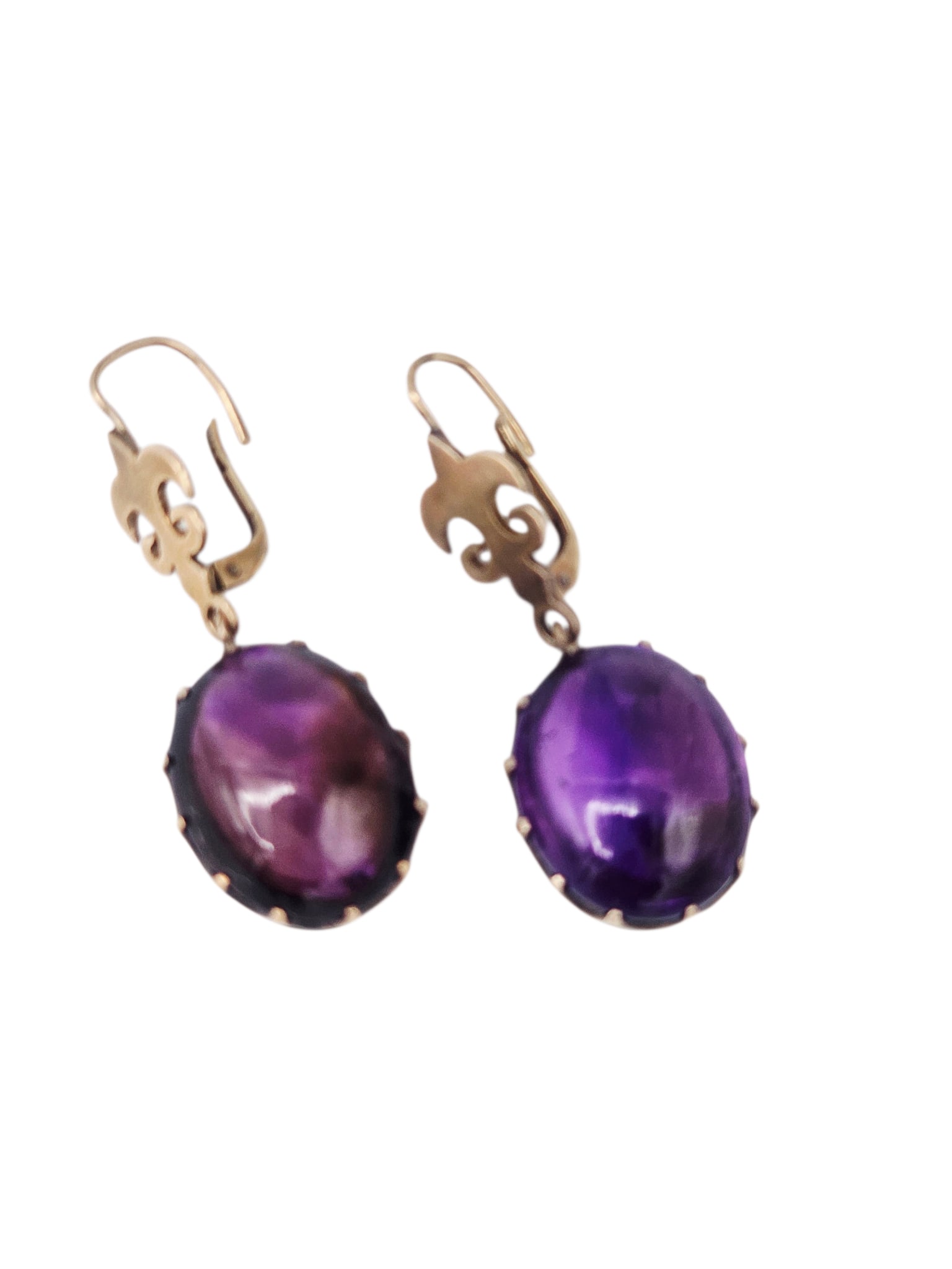 Pair of Amethyst, 14k Yellow Gold Earrings: Each featuring an oval amethyst cabochon measuring approximately 15.50 cts., suspended by 14k yellow gold fleur-de-lis style earring mountings, total length approximately 1.70 inches. Gross weight: 9.