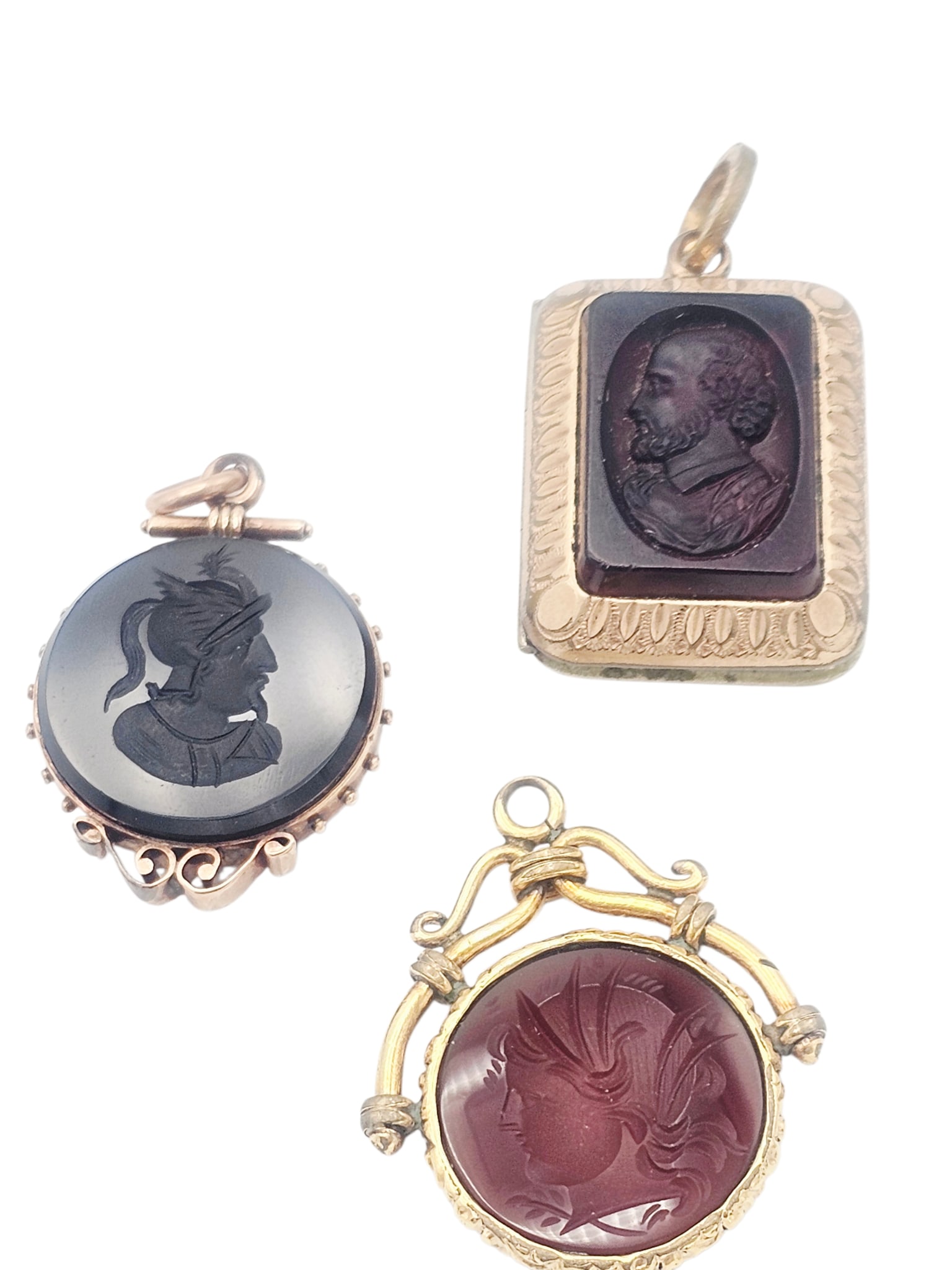 Collection of Three Antique Intaglio and Cameo Fobs: Including one rectangular locket fob featuring a glass cameo of William Shakespeare in profile, reversing to agate, set in a gilt mounting measuring approximately 1.50 x 0.80 inches; one round carneli