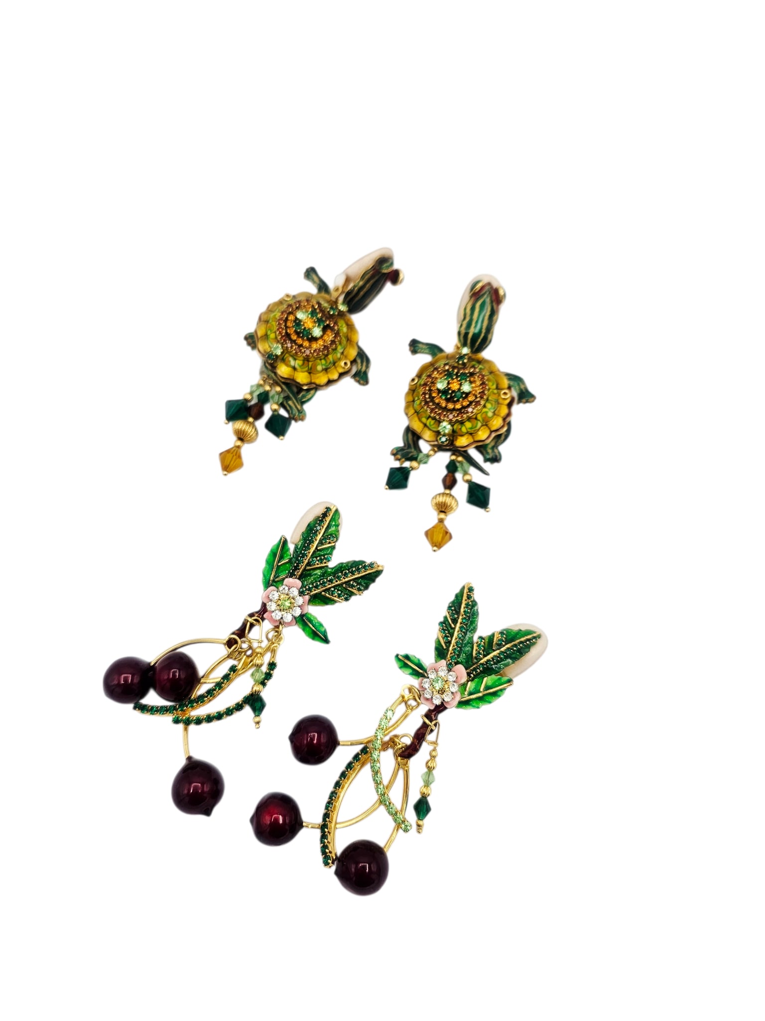 Two Pairs of Lunch at the Ritz Ear Clips: Two pairs of ear clips, each featuring polychrome enamel highlighted with crystal set in gold-tone mountings, including 'Cherries Jubilee,' together with one turtle-themed pair. Both signed: &