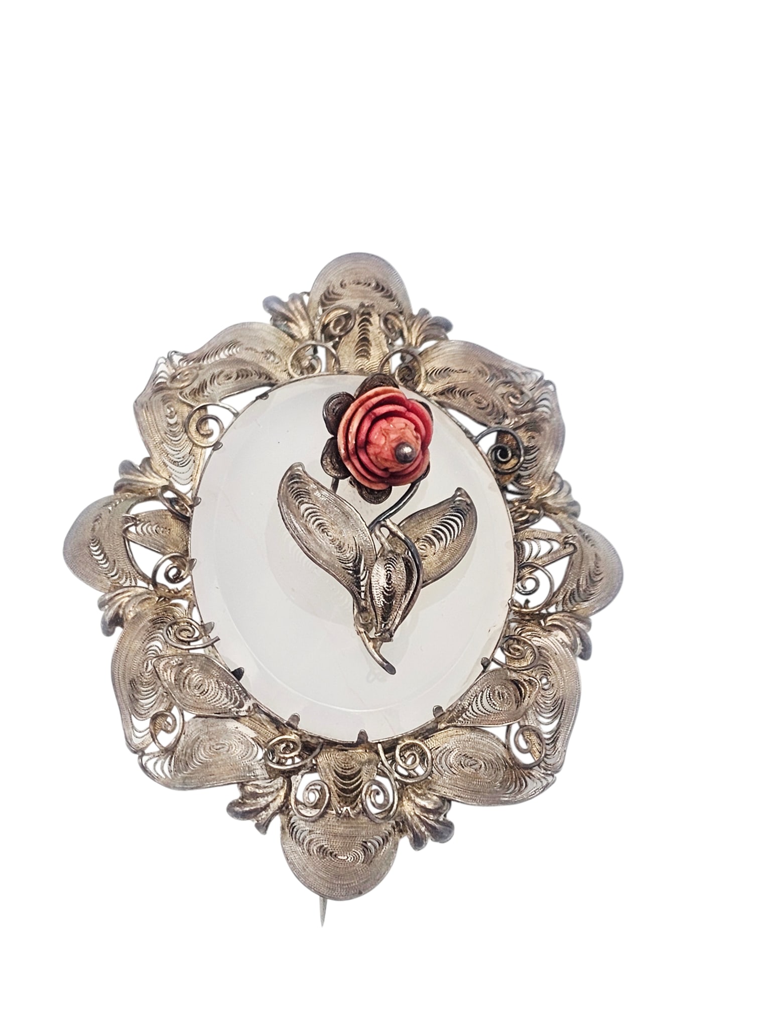 Victorian Chalcedony, Silver Brooch: Centering an oval chalcedony plaque accented by an applied, simulated coral rose, set in a sinuous silver pin mounting measuring approximately 3.00 x 2.45 inches. Gross weight: 30.5 grams.