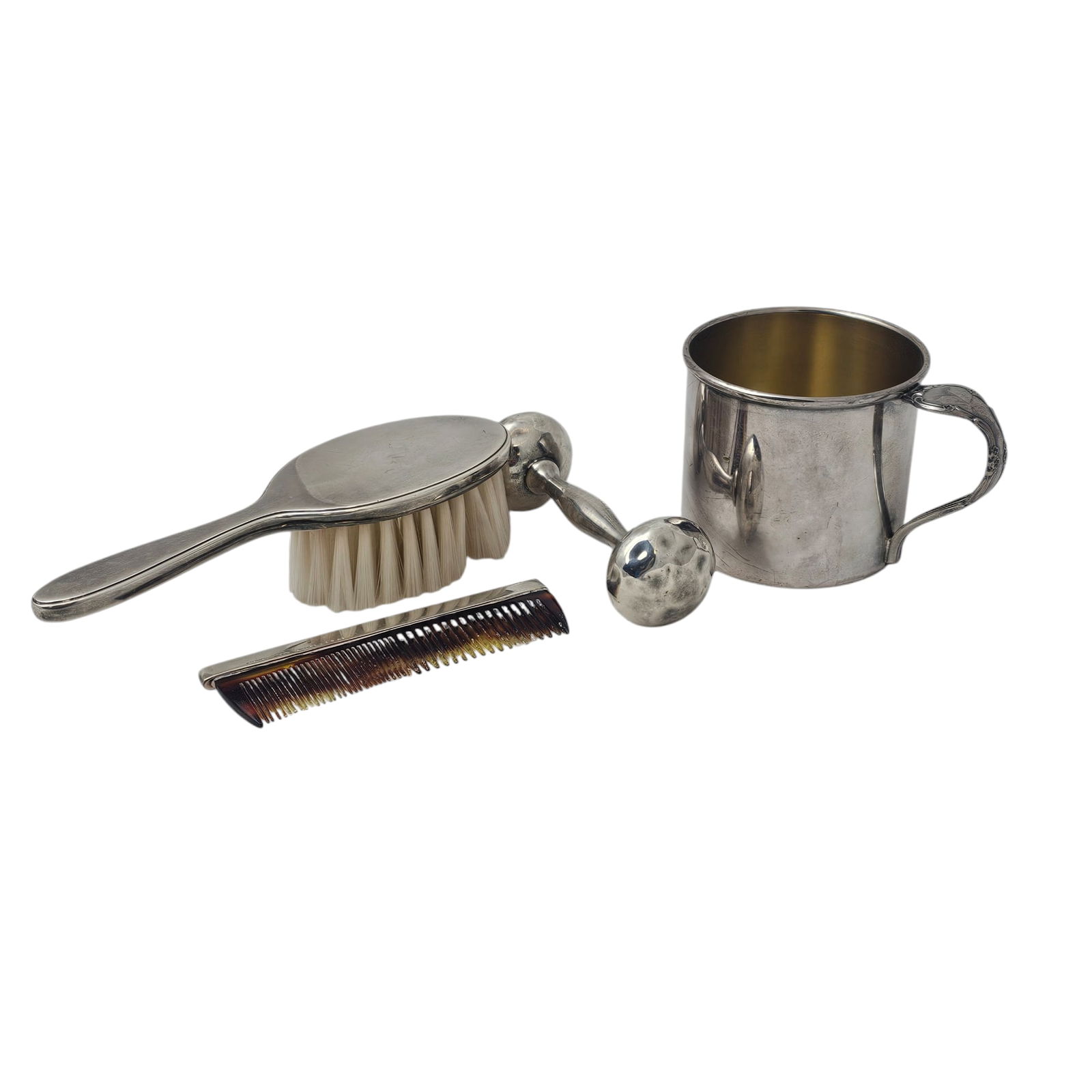Tiffany & Co and Other Baby Silver/Silvertone Items: Brush and comb, with the Tiffany & Co Makers stamp, with individual serial numbers. Other two items appear unmarked, the rattle has indents from use, but still makes a lovely sound, engraved on