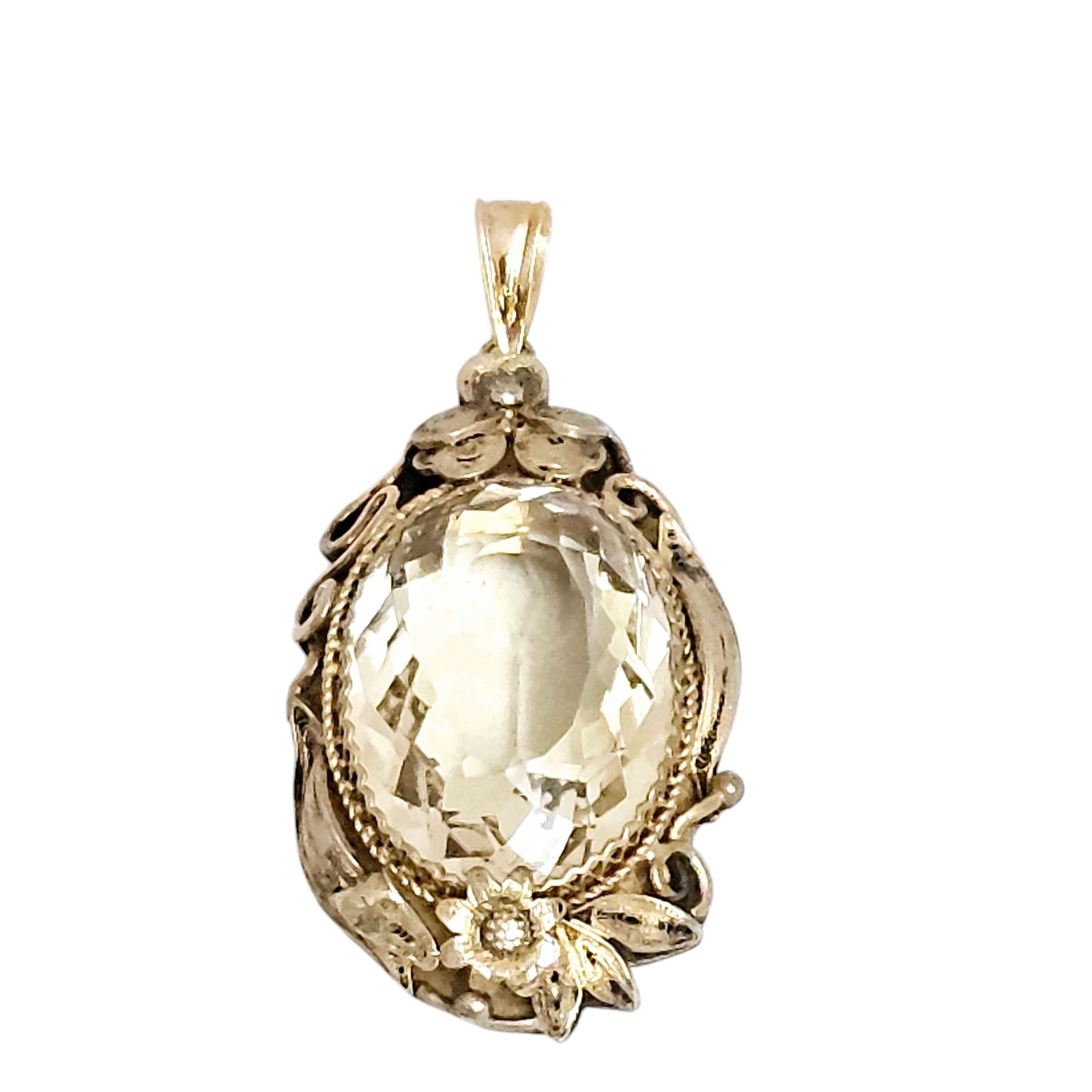 Citrine, Vermeil Pendant: Featuring an oval-cut citrine weighing approximately 34.94 cts., set in a floral, vermeil pendant mounting suspended by a 10k yellow gold bail. Measures approximately 2.27 x 1.10