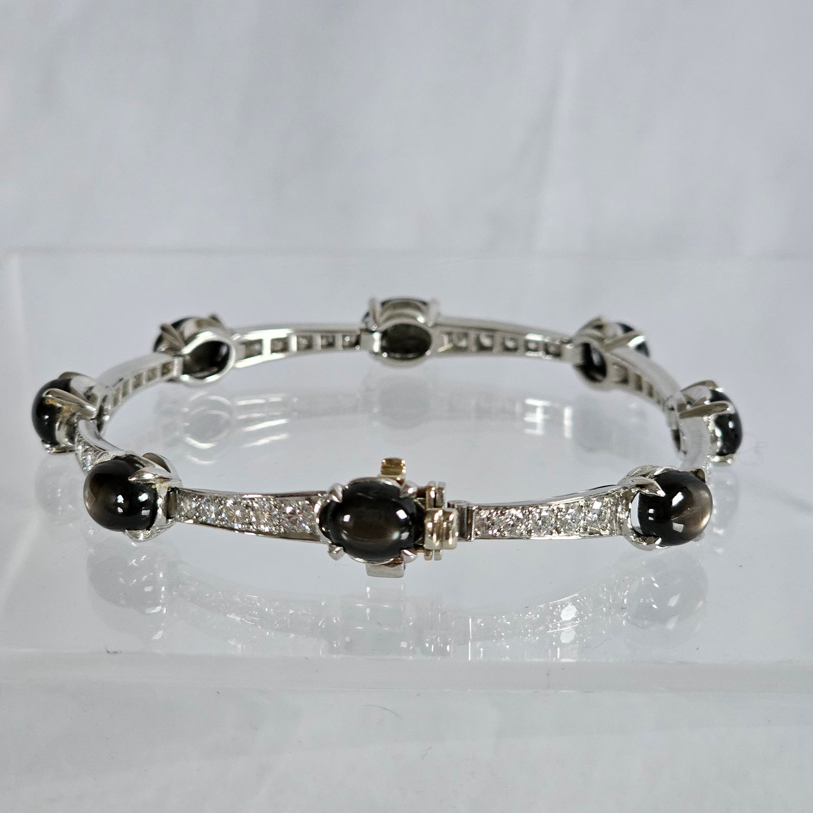 Diamond, Black Star Sapphire, 14k White Gold Bracelet: Featuring eight oval black star sapphire cabochons, each measuring approximately 8.5 x 6.5 mm, accented by forty round brilliant-cut diamonds weighing a total of approximately 2.00 cttw., set in