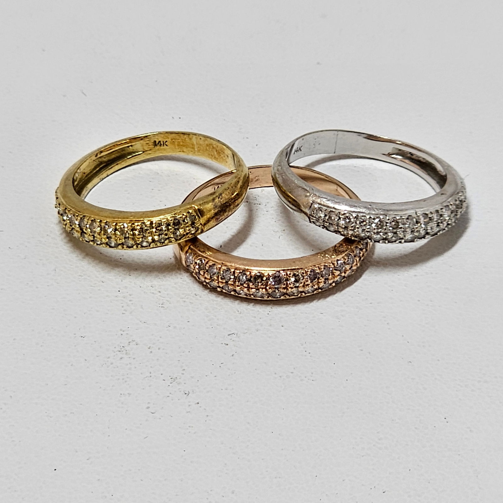 Group of Three Diamond, 14k Stacking Rings: Each featuring pave-set full-cut diamonds weighing a total of approximately 0.54 ctw., set in a 14k rose, 14k green, and 14k white gold ring mounting. Size 8. Total diamond carat weight for the three
