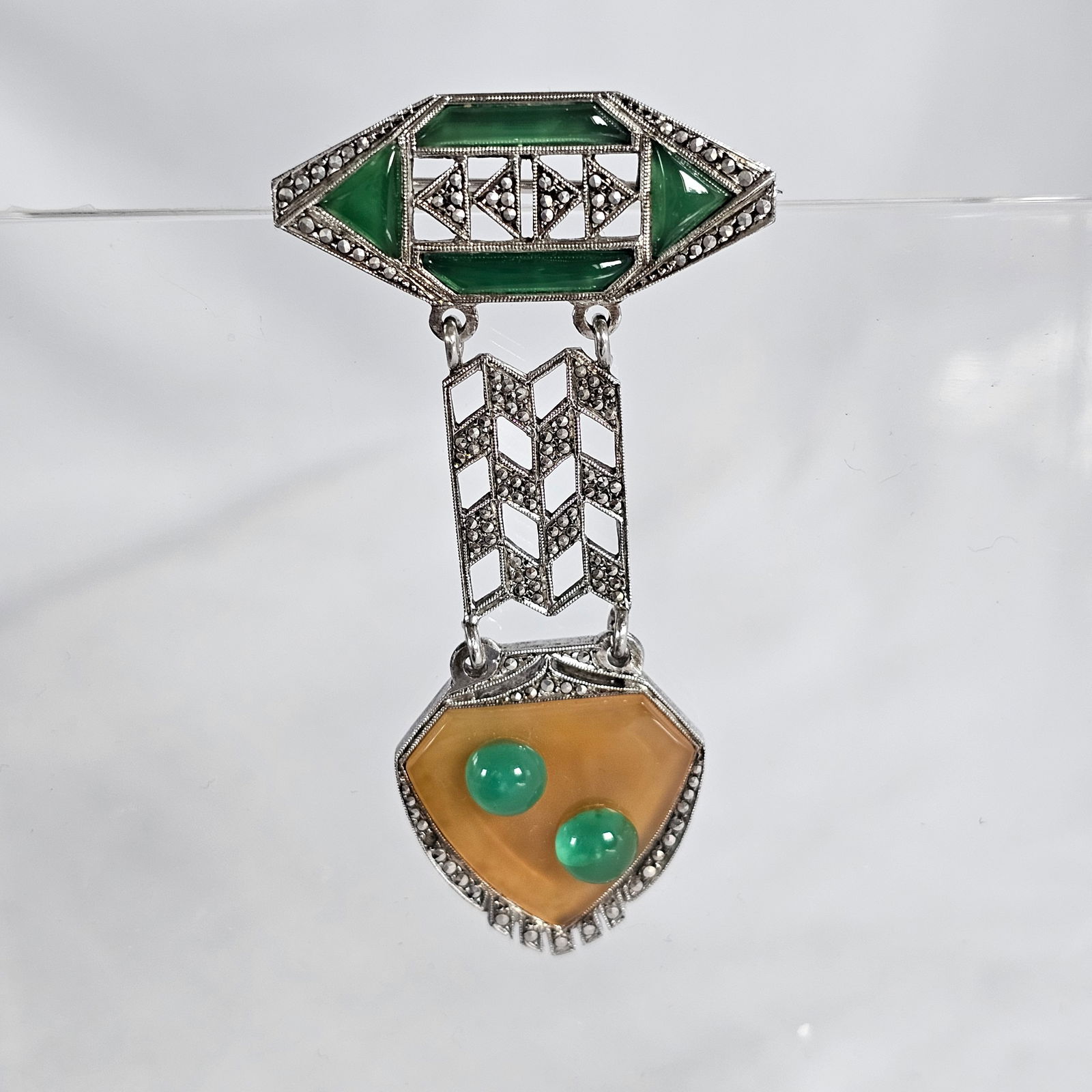 Art Deco Marcasite, Glass Pin: Featuring green and light orangish-brown glass highlighted by numerous marcasite, set in an articulating sterling silver pin mounting measuring approximately 67.0 x 36.0 mm (2.65 x 1.40 in). Gross