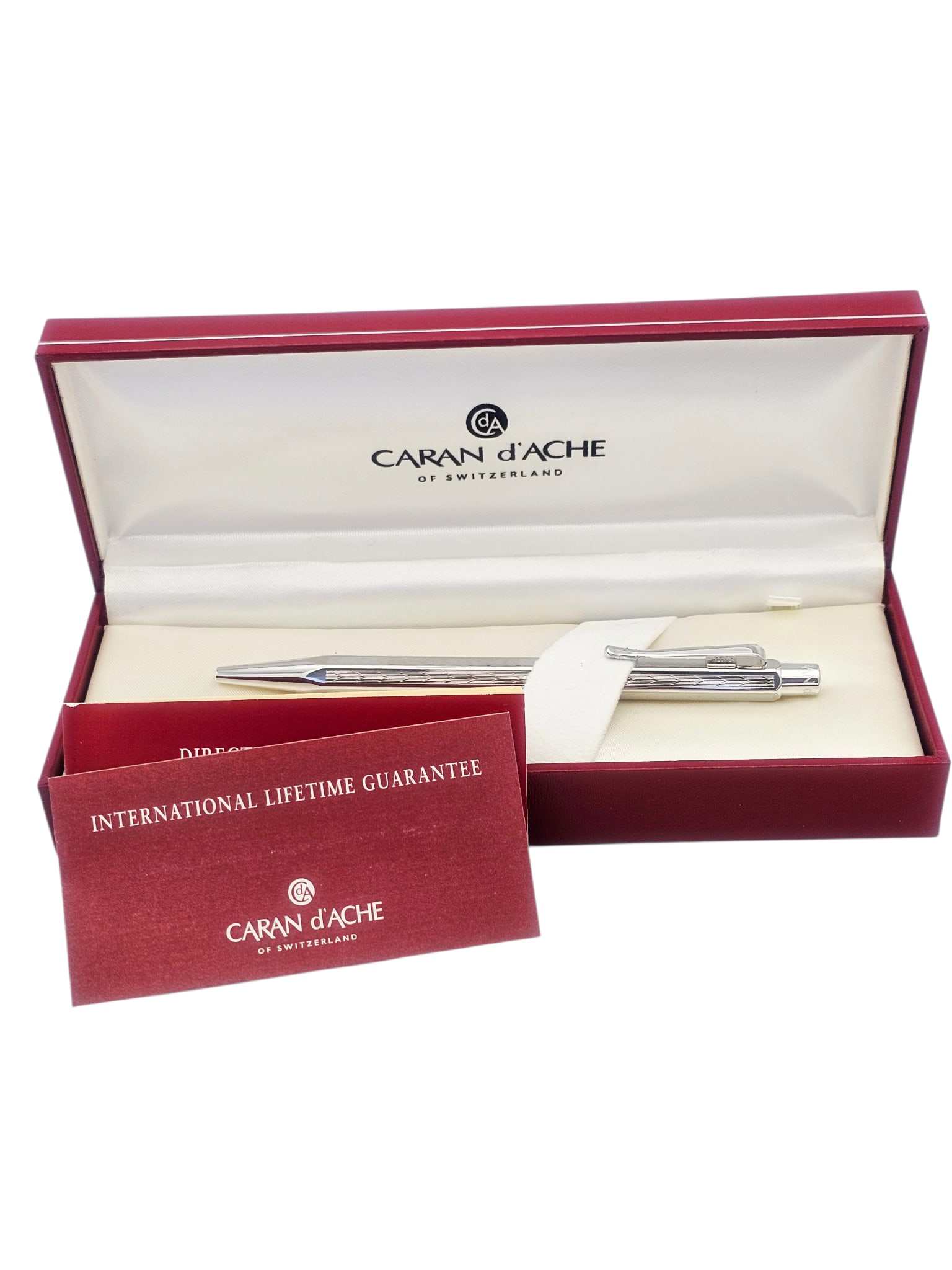 Caran d'Ache Ballpoint Pen: Retractable silver-tone ballpoint pen measuring (H) 5.03 x (W) 0.34 inches. Accompanied by original boxes and papers.