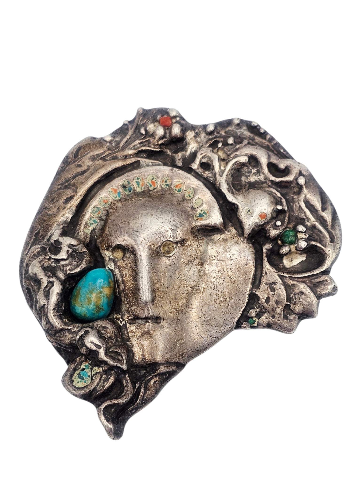 Multi-Stone, Sterling Silver Buckle: Designed as a face amongst leaves and flowers, accented by chrysocolla, coral and malachite cabochons, set in a sterling silver buckle mounting measuring approximately 3.60 x 3.20 inches. Unsigned.