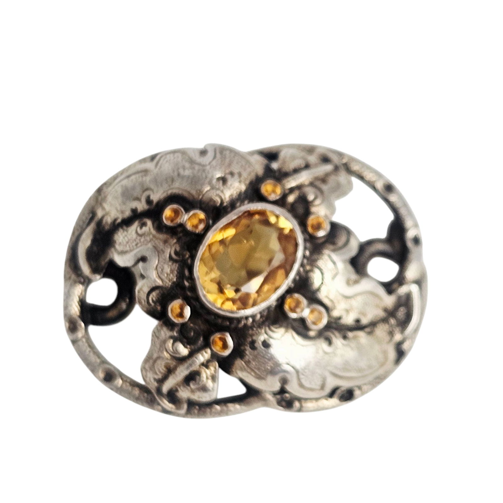 Victorian Citrine, Sterling Silver Pin: Centering an oval-cut citrine weighing approximately 2.45 cts., accented by eight round-cut citrines, set in a foliate-motif, sterling silver pin mounting measuring approximately 1.50 x 1.10 inches.