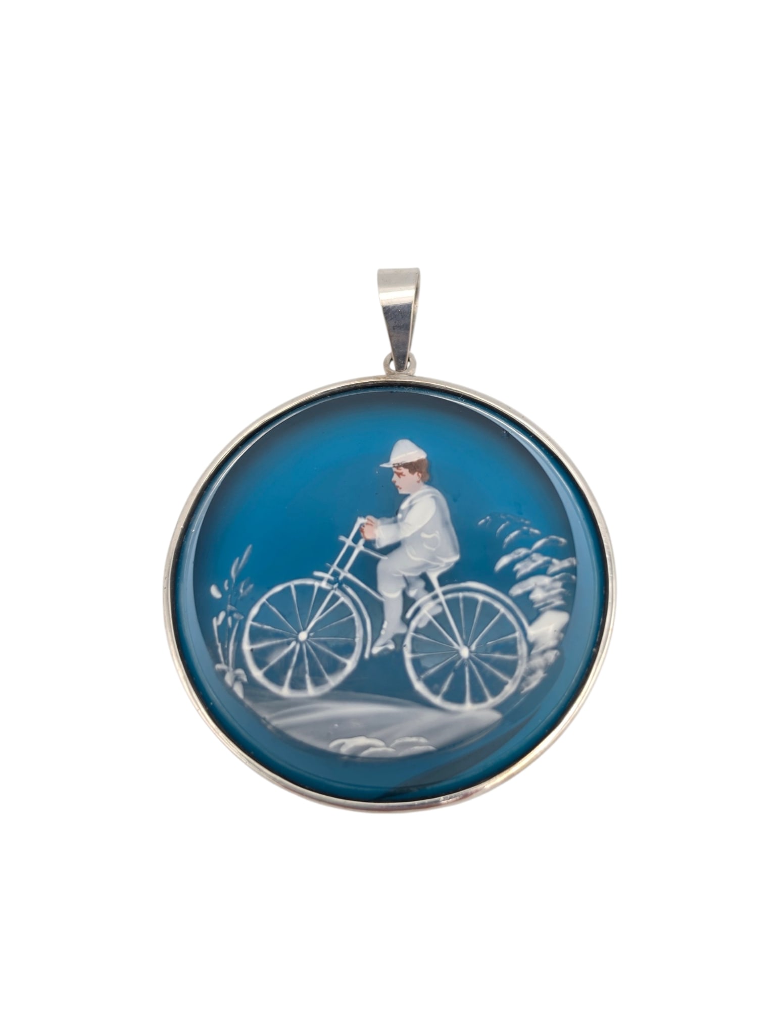 Mary Gregory Bohemian Glass, 14k Pendant: The blue Bohemian glass disc with hand-painted enamel, centering a scenic depiction of a man on a bicycle, set in a 14k white gold pendant mounting measuring approximately 2.75 x 2.18 inches