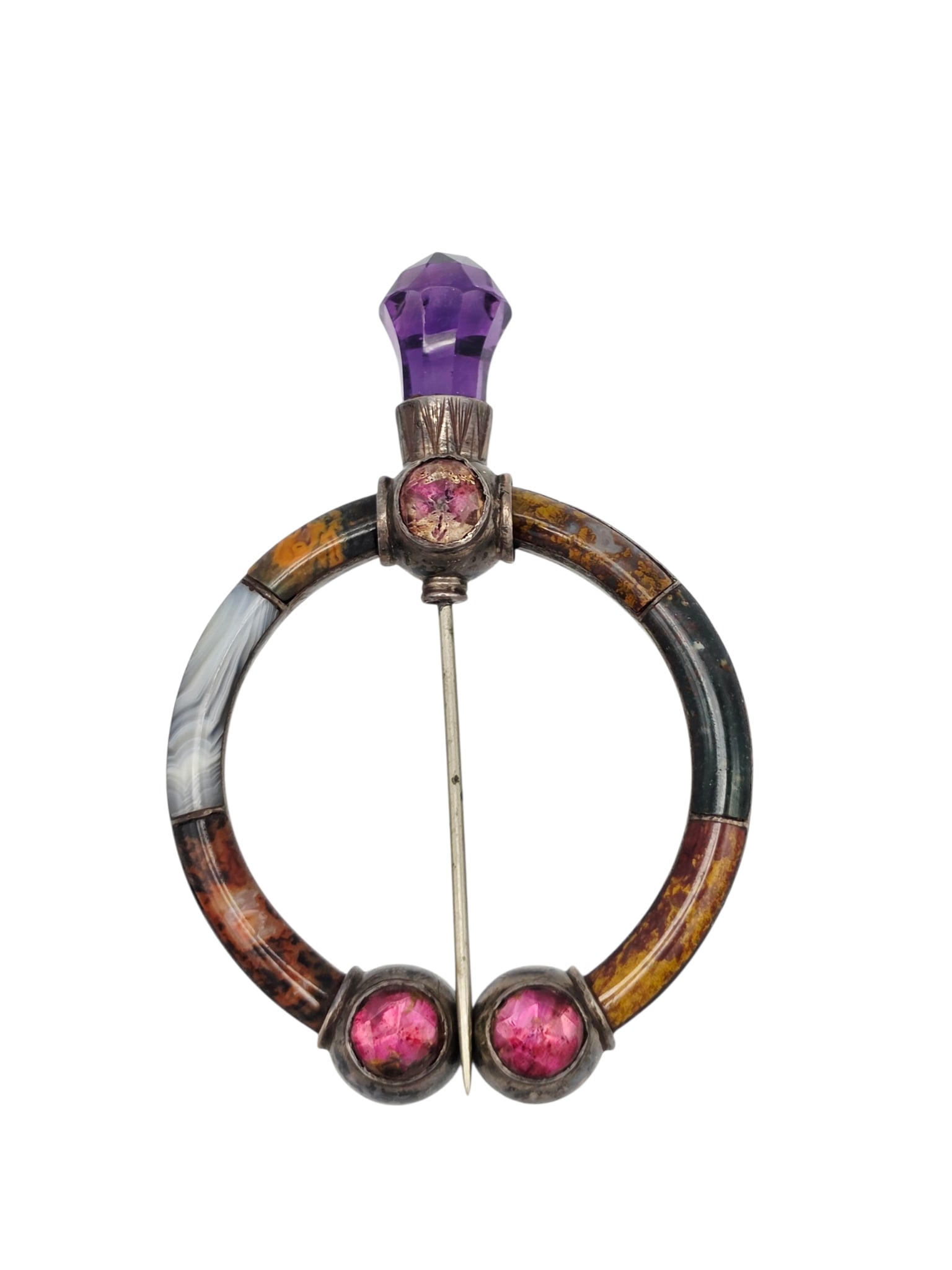 Scottish Amethyst, Agate, Sterling Silver Pin: Featuring a carved amethyst finial accented by circular foiled glass and multi-colored inlaid agates, set in a fibula style, sterling silver pin mounting measuring approximately 2.65 x 1.95 inches. Gr