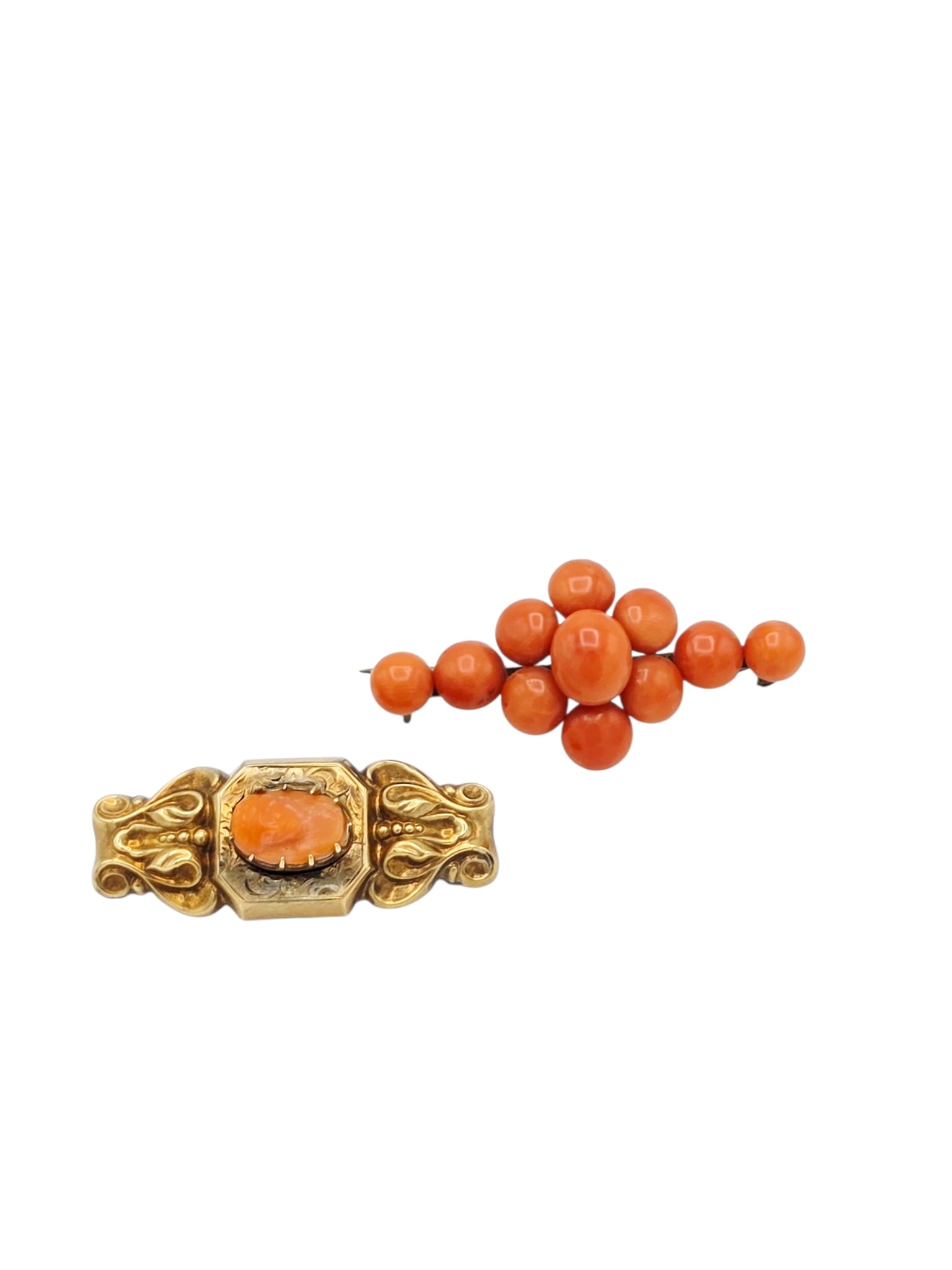 Collection of Two Victorian Coral Pins: Including one bar pin featuring eleven round and oval coral cabochons set in a silver mounting measuring approximately 1.75 to 0.80 inches; together with one pin centering a coral cameo, set in
