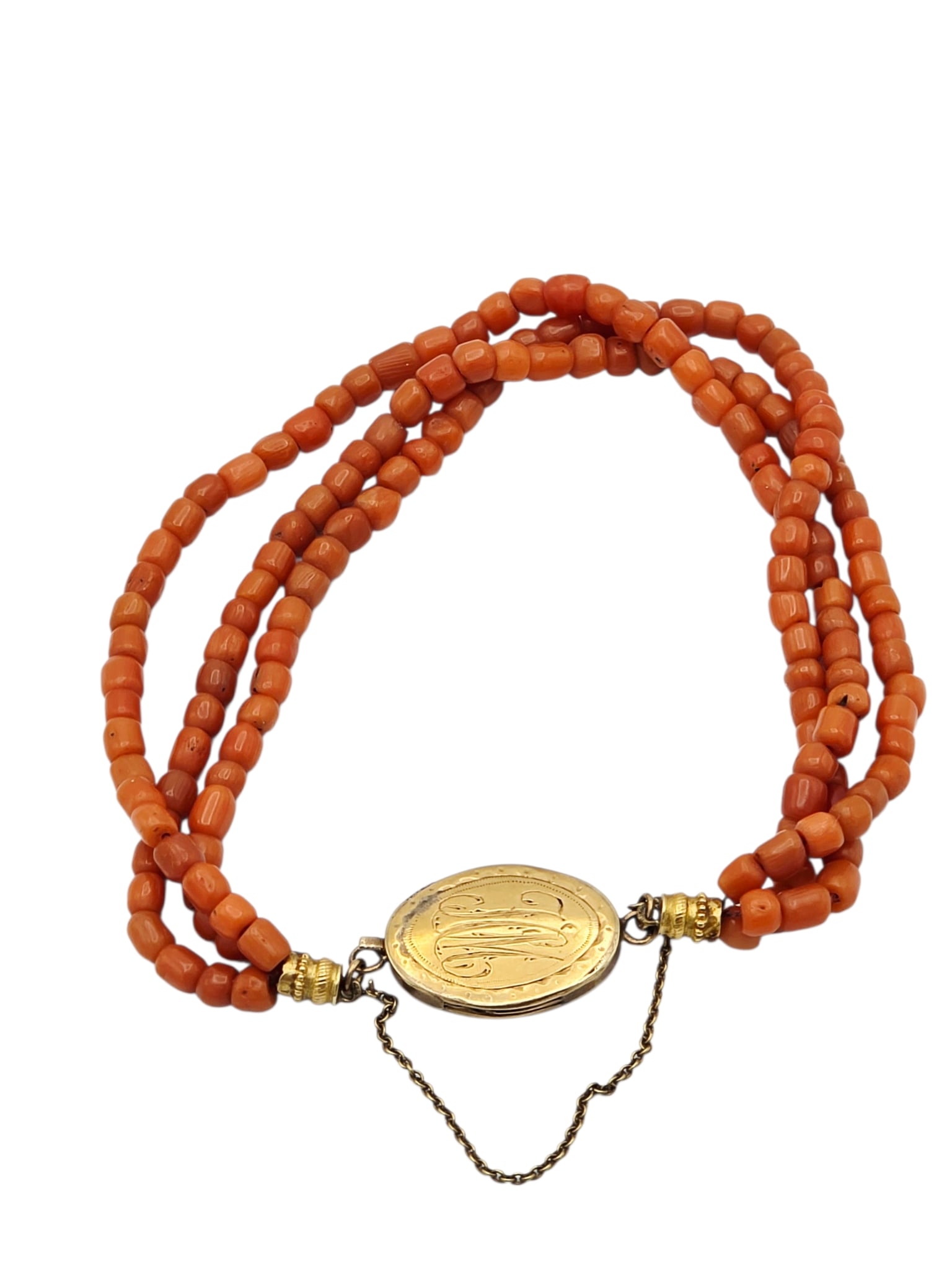 Victorian Coral, Yellow Gold Bracelet: Composed of multiple coral beads joined to a 14k yellow gold monogrammed push-release clasp with safety chain, forming a three strand, 7 inch bracelet. Gross weight: 13.0 grams. Condition: clasp has b