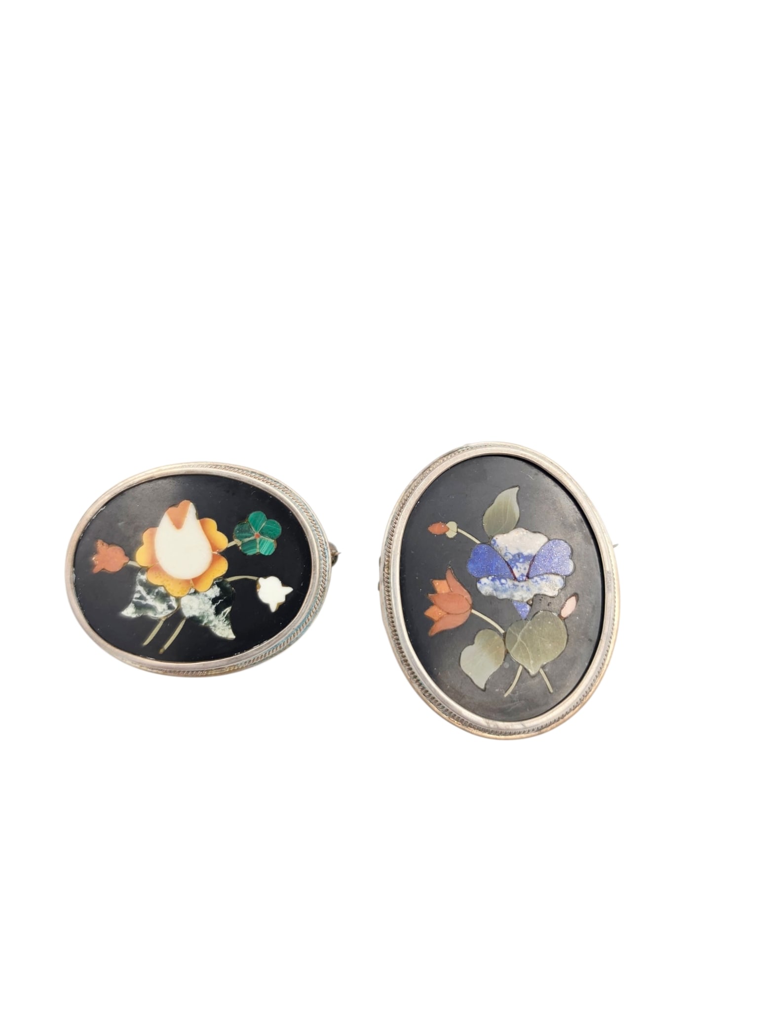 Two Pietra Dura, Silver Pins: Each designed as an inlaid spray of flowers set in an oval silver mounting, including one pin pendant measuring approximately 1.80 x 1.40 inches; together with one pin measuring approximately 1.60 x 1
