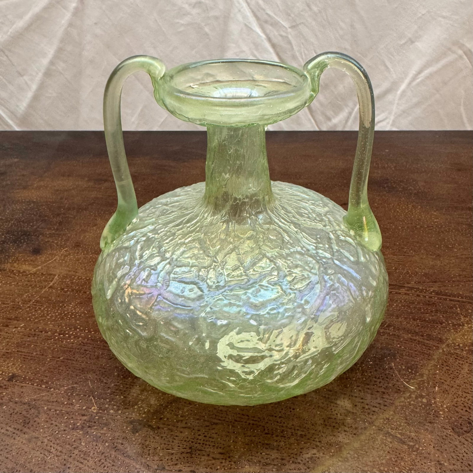 Art Nouveau Iridescent Uranium Glass Vessel: Art Nouveau uranium glass green bulbous vessel with textured surface, double handle, and iridescent finish.