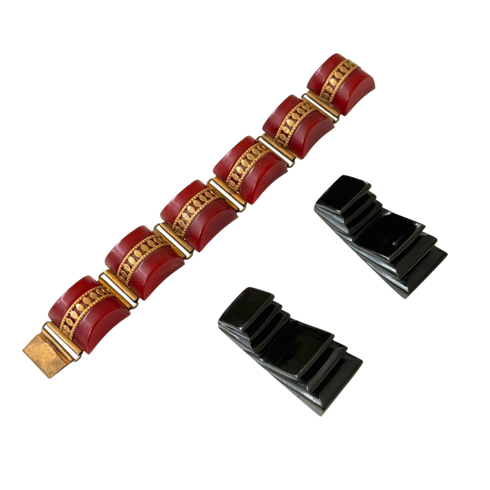 (Lot of) 3 Vintage Bakelite Costume Items: (Lot of) 3 vintage Bakelite items including one bracelet in brass and domed red Bakelite and a pair of shoe clips in black.