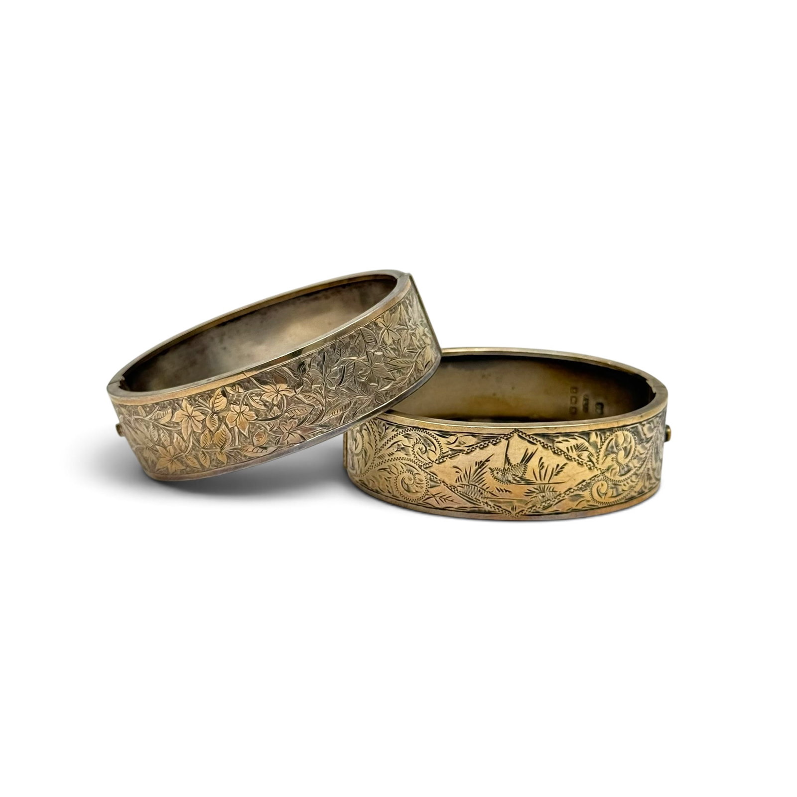 Two Victorian Sterling Silver Bracelets: Including one bracelet engraved with birds, scrolls and leaves, set in a hinged, sterling silver mounting measuring approximately 0.75 inches (19.0 mm) in width, completed by a tongue-and-groove clasp
