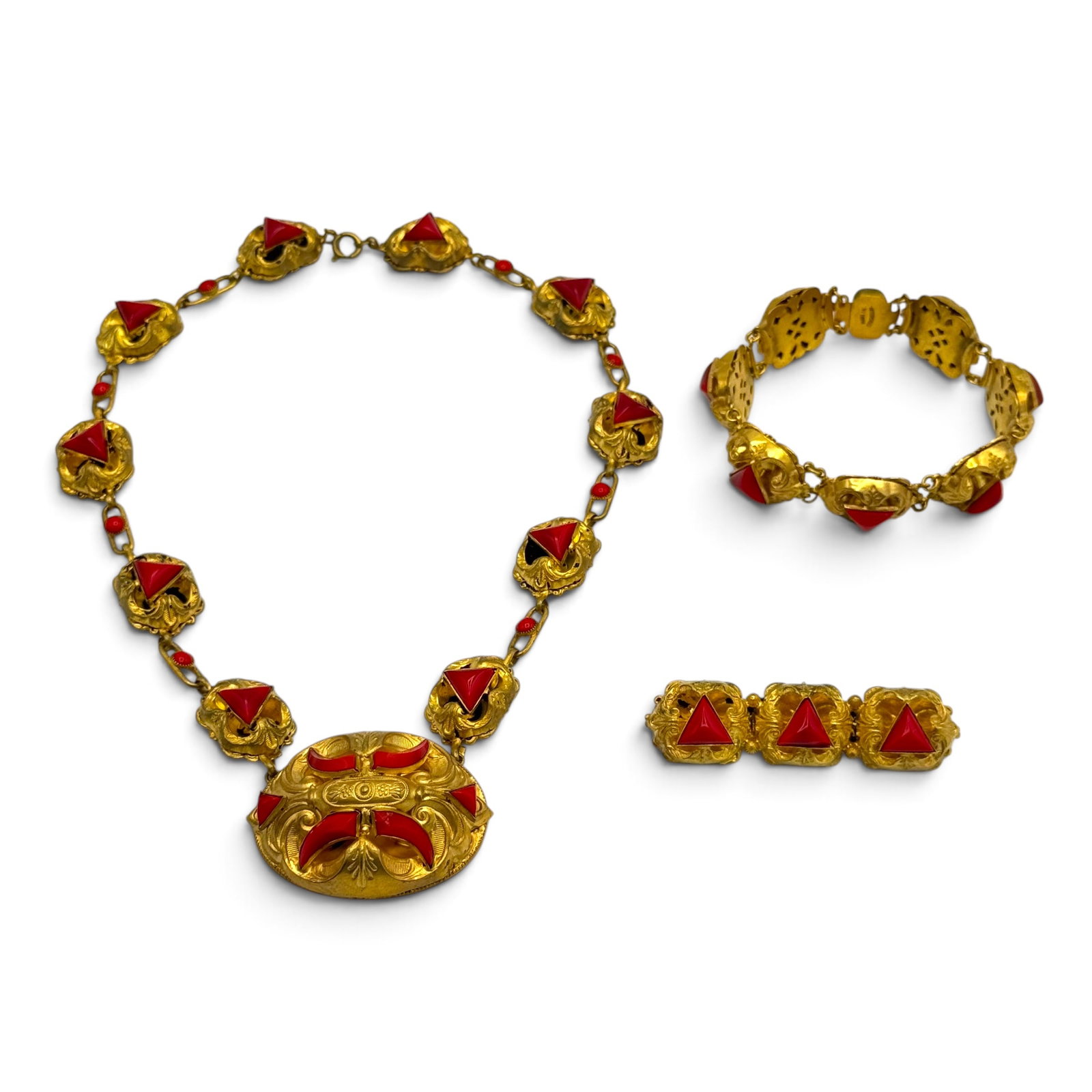 Vintage Czech Glass, Gold-Tone Jewelry Suite: Including a necklace designed as repousse links accented by red glass, 16 inches; a matching 7 inch bracelet; and bar pin measuring approximately 2.35 x 0.65 inches. All marked 'Czechoslovakia'
