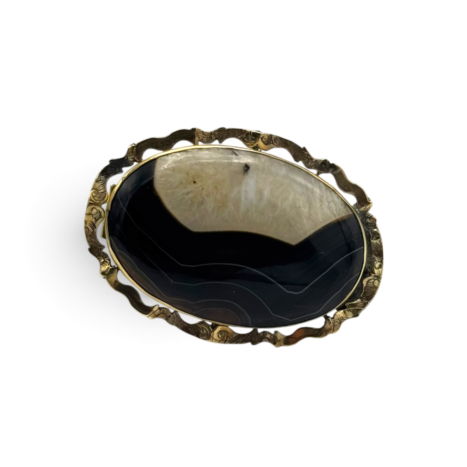 Victorian Banded Agate, Yellow Gold Pin: Centering an oval banded agate cabochon set in an engraved 9-10k yellow gold pin mounting measuring approximately 1.65 x 1.20 inches. Gross weight: 8.8 grams.