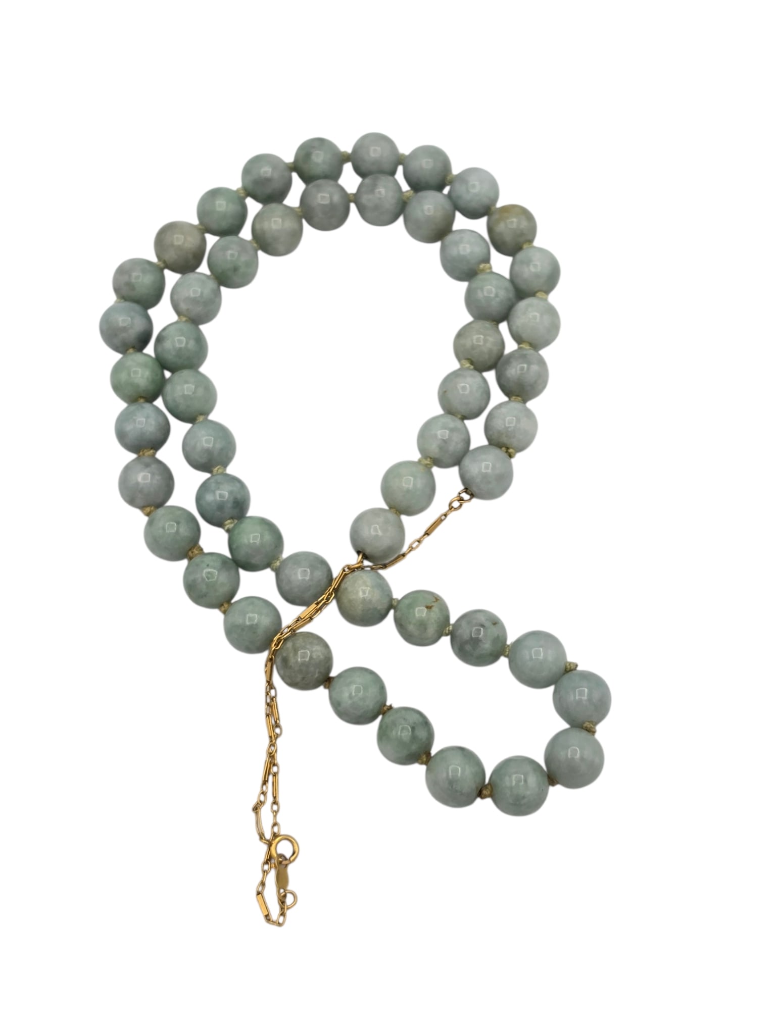 Jade, 14k Yellow Gold Necklace: Composed of fifty-one round jade beads, each measuring approximately 9.0 mm, completed by a 14k yellow gold lobster claw clasp with chain extender, forming a 26 inch necklace. Gross weight: 67.