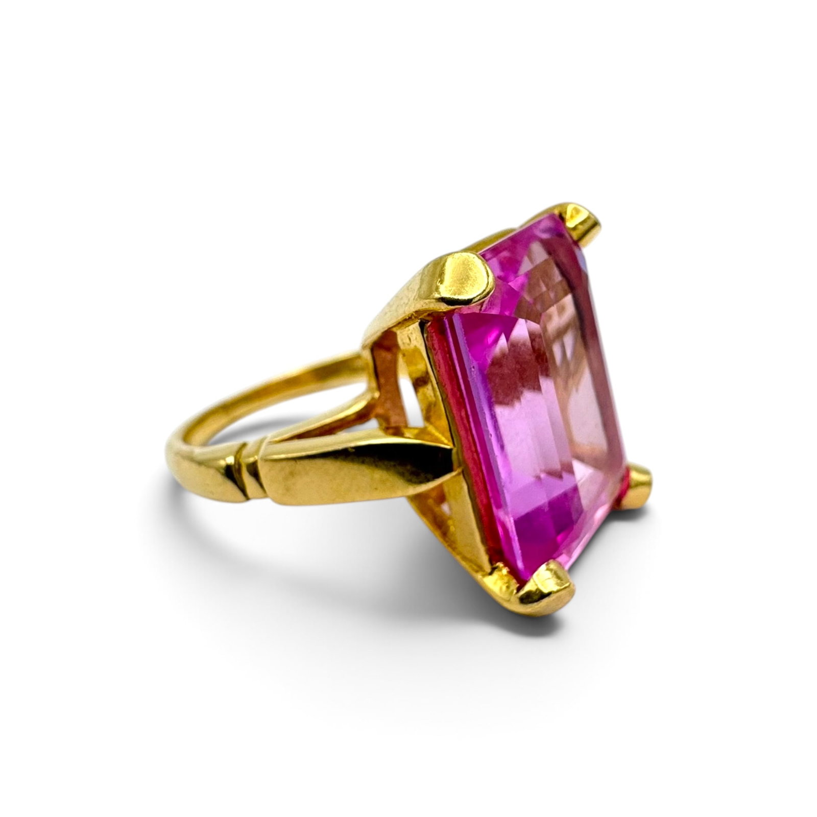 Synthetic Sapphire, 14k Yellow Gold Ring: Featuring one emerald-cut synthetic pink sapphire measuring approximately 18.0 x 13.0 mm, set in a 14k yellow gold ring mounting, size 6 1/4. Gross weight: 12.1 grams.