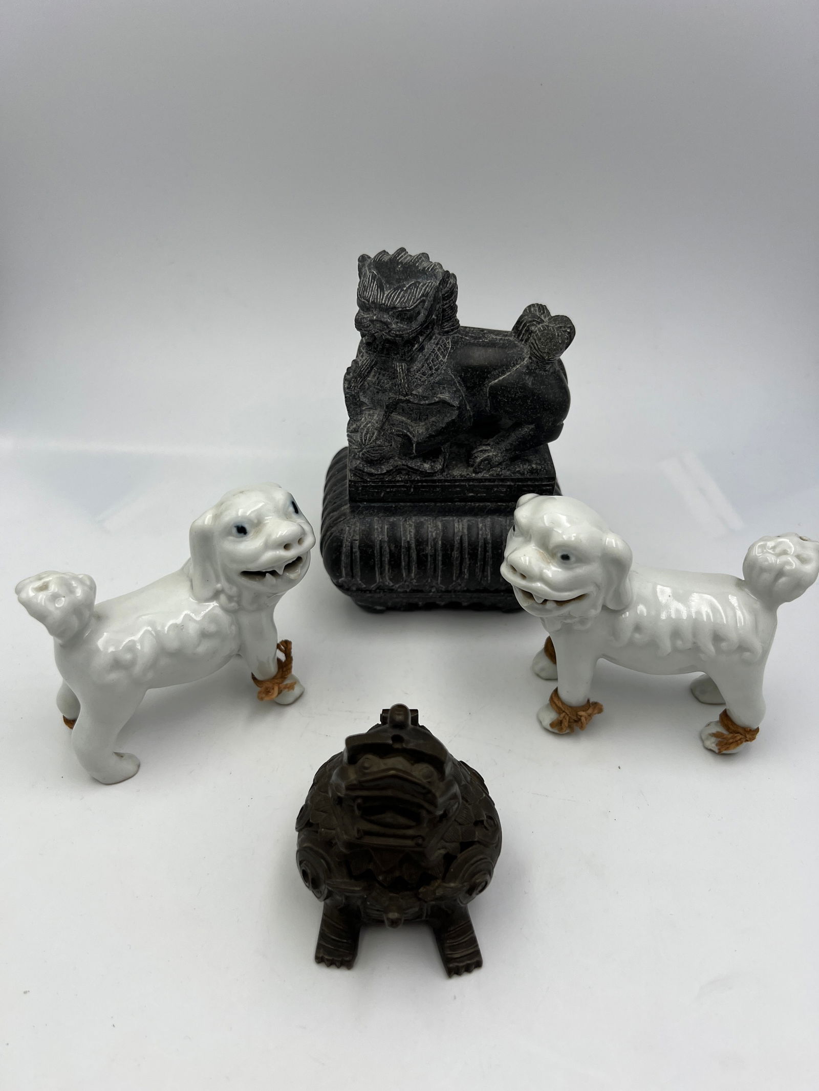 Assortment of Foo Dog Figurines: Made of porcelain, bronze, and soapstone. Nice condition. Ht: 5" max.