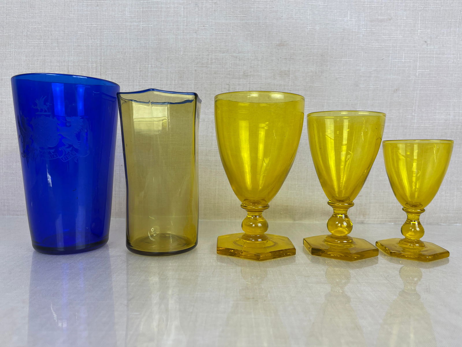 Asstd. Steuben Amber & Cobalt Blue Glass w/ Crest: Set of 3 goblets marked Steuben. Cobalt blue glass says "Mea Gloria Fides" under crest. Good condition. Ht: 6" max.