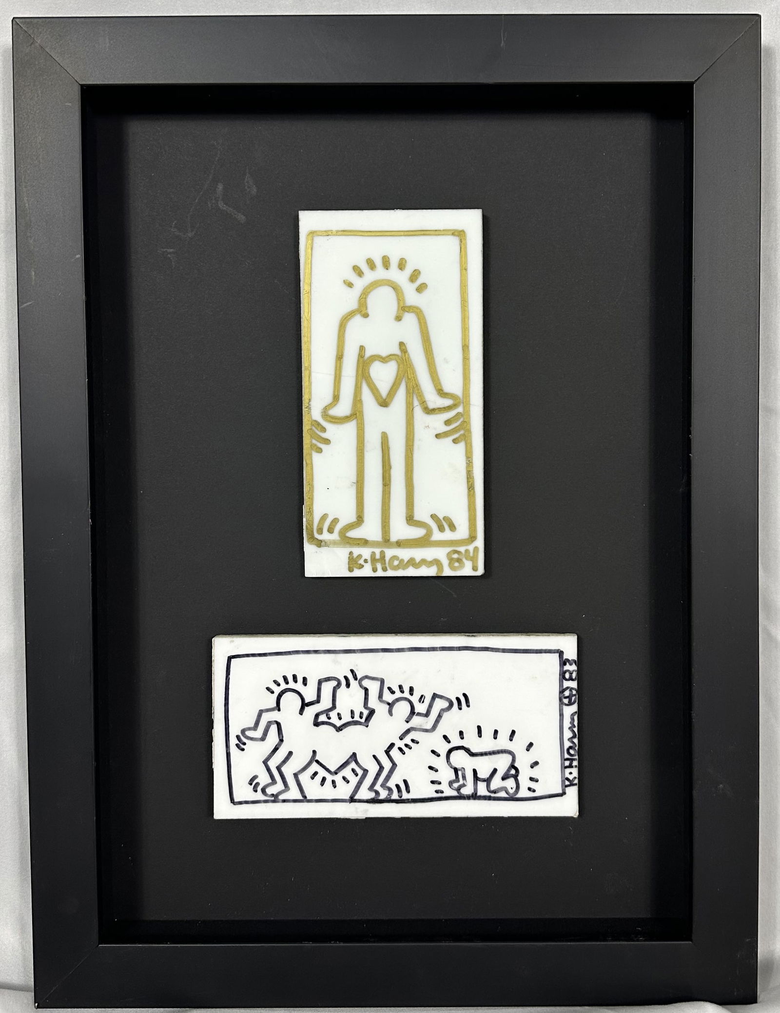 Kieth Haring Two Framed Drawn and Signed Tiles: Two fantastic examples of Kieth Haring art done on old tiles. Please note the tiles were removed from a wall and have some minor knicks and chips as seen in the photos. Haring was known for doing art