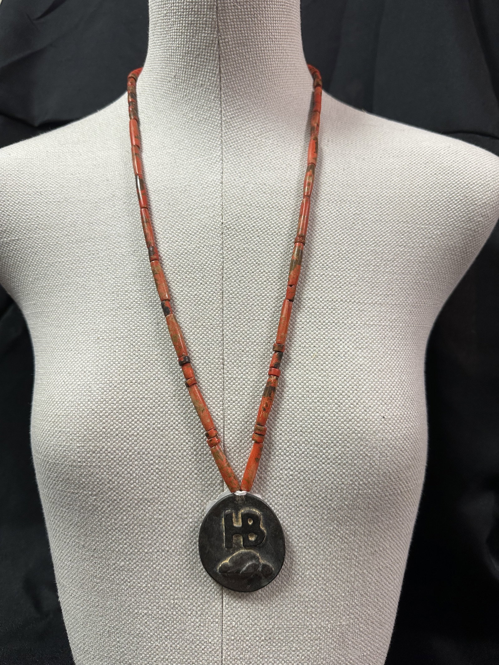 Hudson Bay - Cast Hudson Bay Logo Pendant on a Trade Bead Neckalce: Hudson Bay logo pendant with what looks like maybe an otter underneath the HB hanging off of a trade bead necklace. The Hudson Bay company has been around since 1670. It is a Canadian company that for