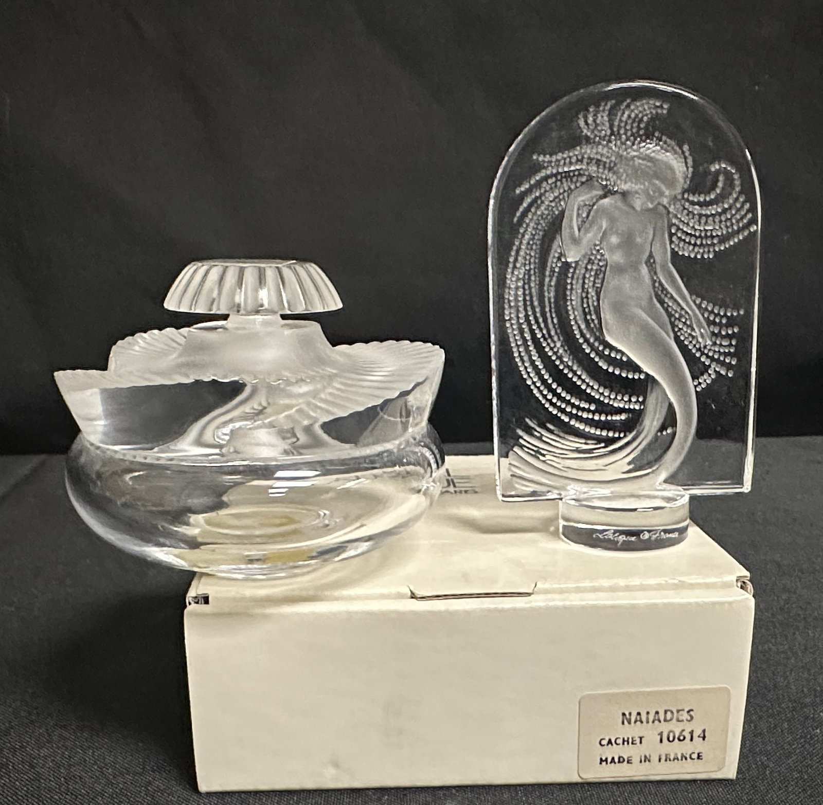 Lalique Baptiste Perfume Bottle and Lalique Naiades with Box: Attractive and discontinued Lalique Baptiste perfume bottle along with a Lalique Naiades sculpture with its own box. Both in good condition as you can see.