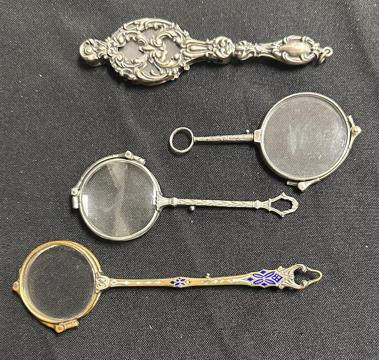 Group of Four Lorgnettes: Grouping of four lorgnettes three of which are silver and one with blue enamel. All different types represented.