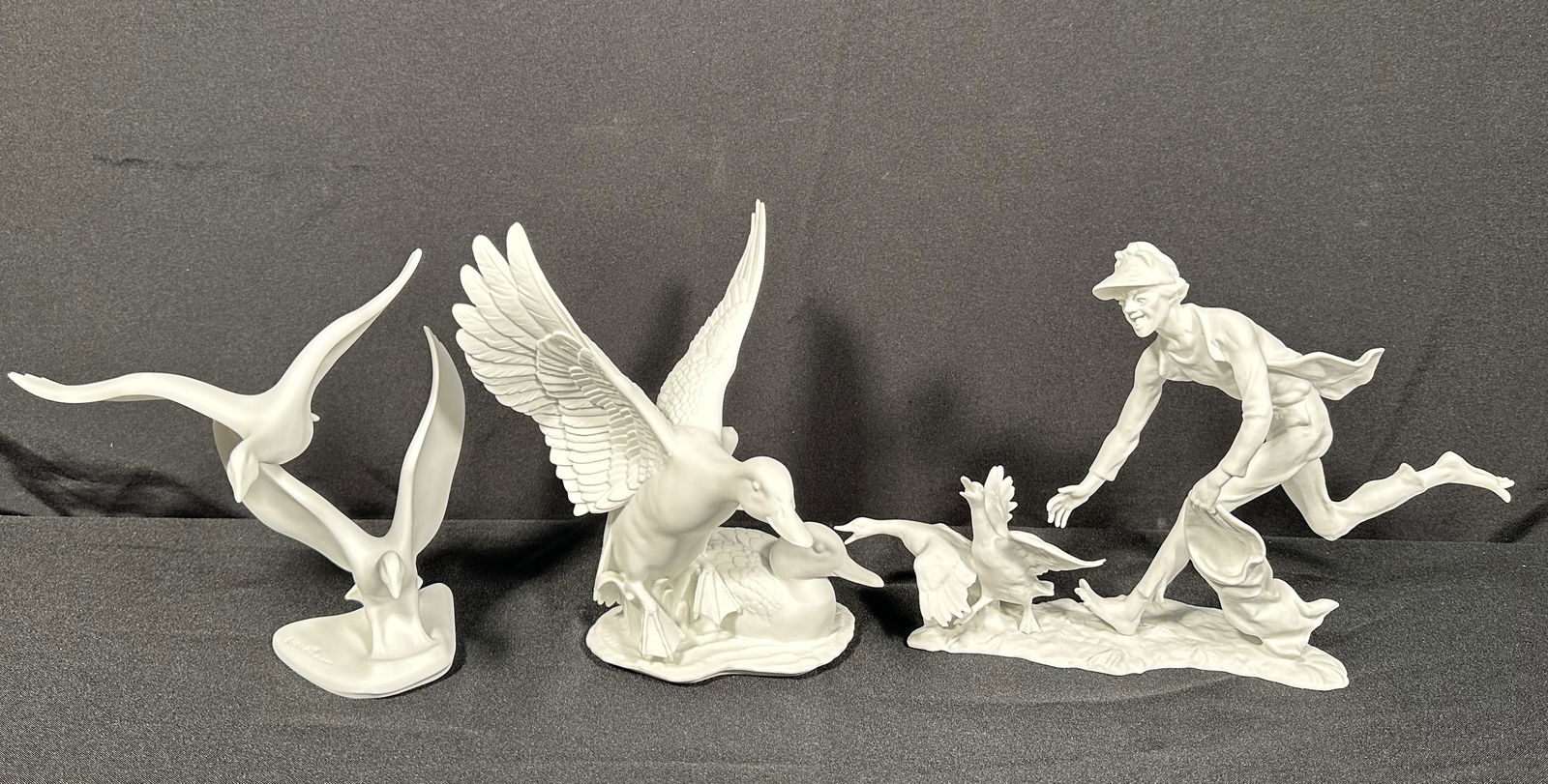 3 Kaiser Bisque Porcelain Bird Themed Figures: Three Kaiser bird related bisque figurines including the larger piece of the man chasing two ducks. Please see photos for the condition to confirm, we found no issues at a cursory glance.This auction