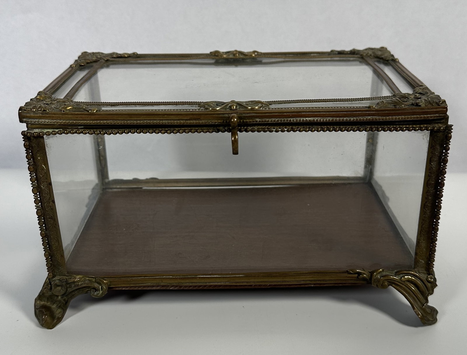 RR Antique Brass and Glass Jewelry Casket: Antique Brass and Glass Jewelry Casket This is an antique French gilt jewelry casket featuring glass panels, rococo-style feet, and a brass metal frame. For this lot shipping can be done one of two