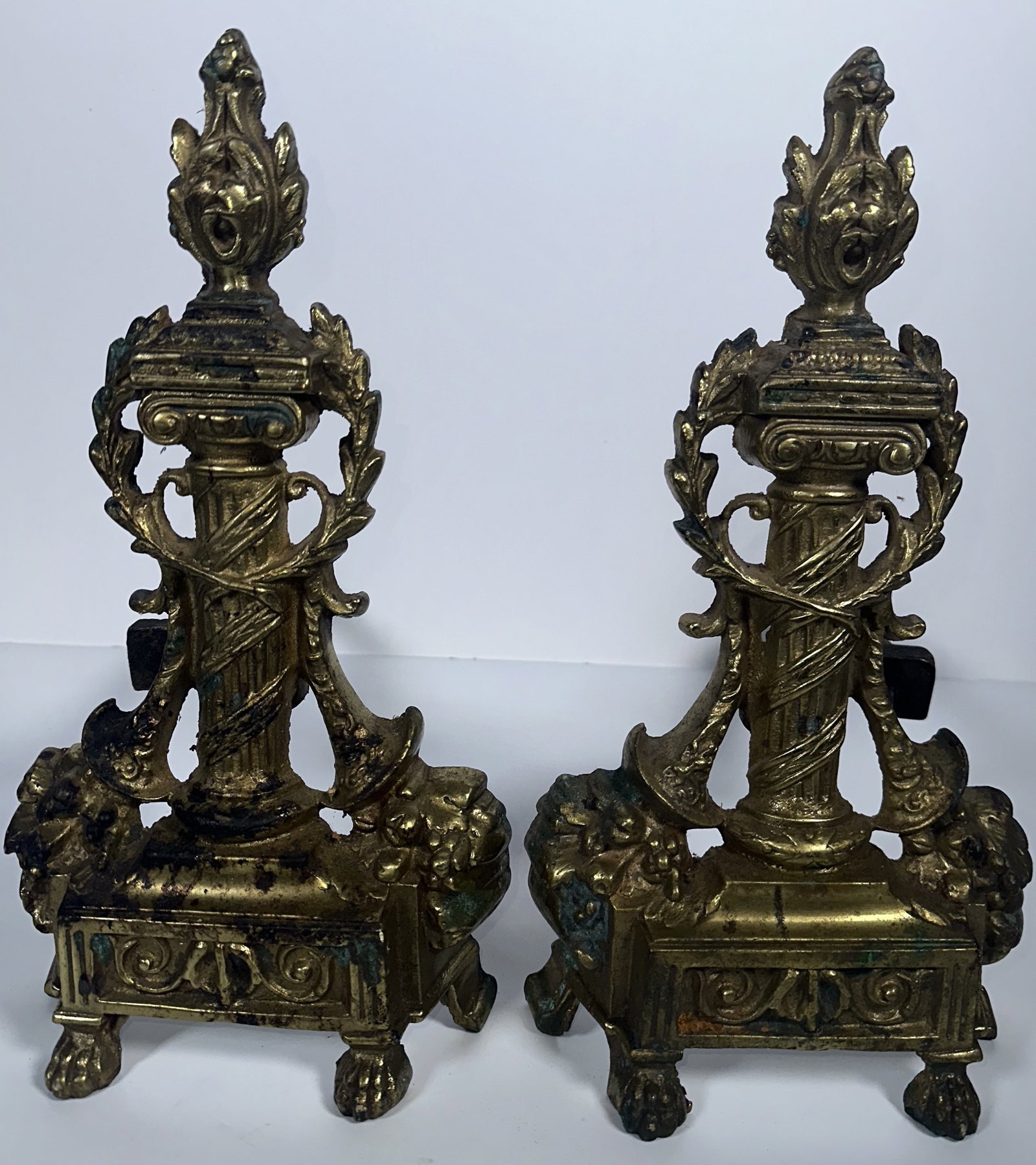 Pair of Antique Classical Gilt Andirons: Pair of Antique Classical Gilt Andirons This pair of vintage French Empire or Louis XVI style cast andirons features classical reeded columns, flame finials, and ornate paw feet. They showcase traditi
