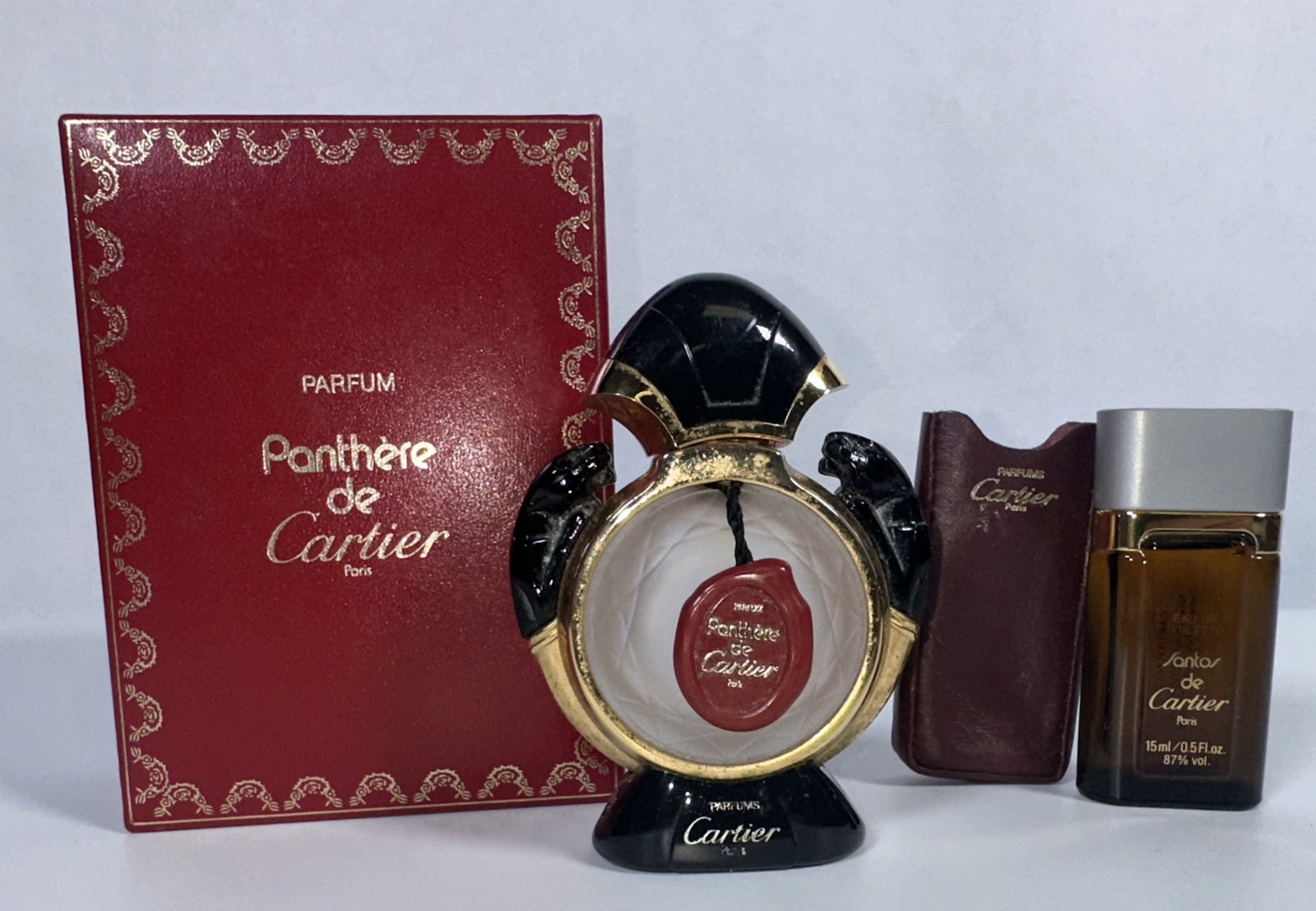 Pair Cartier Perfume Bottles Panthere and Santos: Pair Cartier Perfume Bottles Panthere and Santos This lot includes a Cartier Panthere perfume bottle with its original box. The box hinge is a little loose. The lot also includes a Cartier Santos Eau 