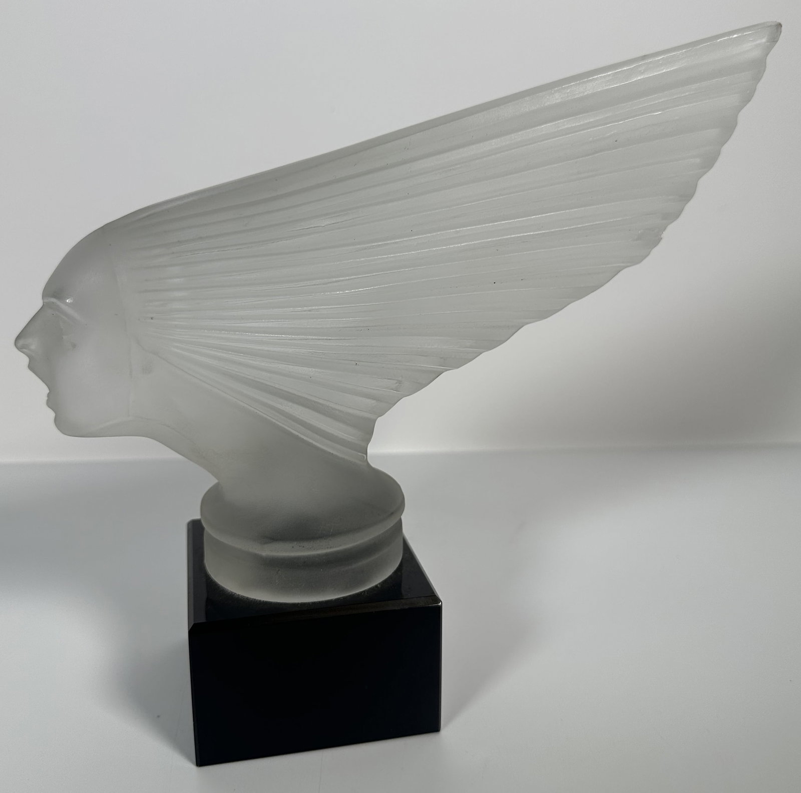 Frosted Glass Head Car Mascot on Stand: Frosted Glass Head Car Mascot on Stand his is the iconic Victoire (Spirit of the Wind) car mascot and crystal sculpture, originally designed by Ren? Lalique in 1928 and crafted from molded frosted