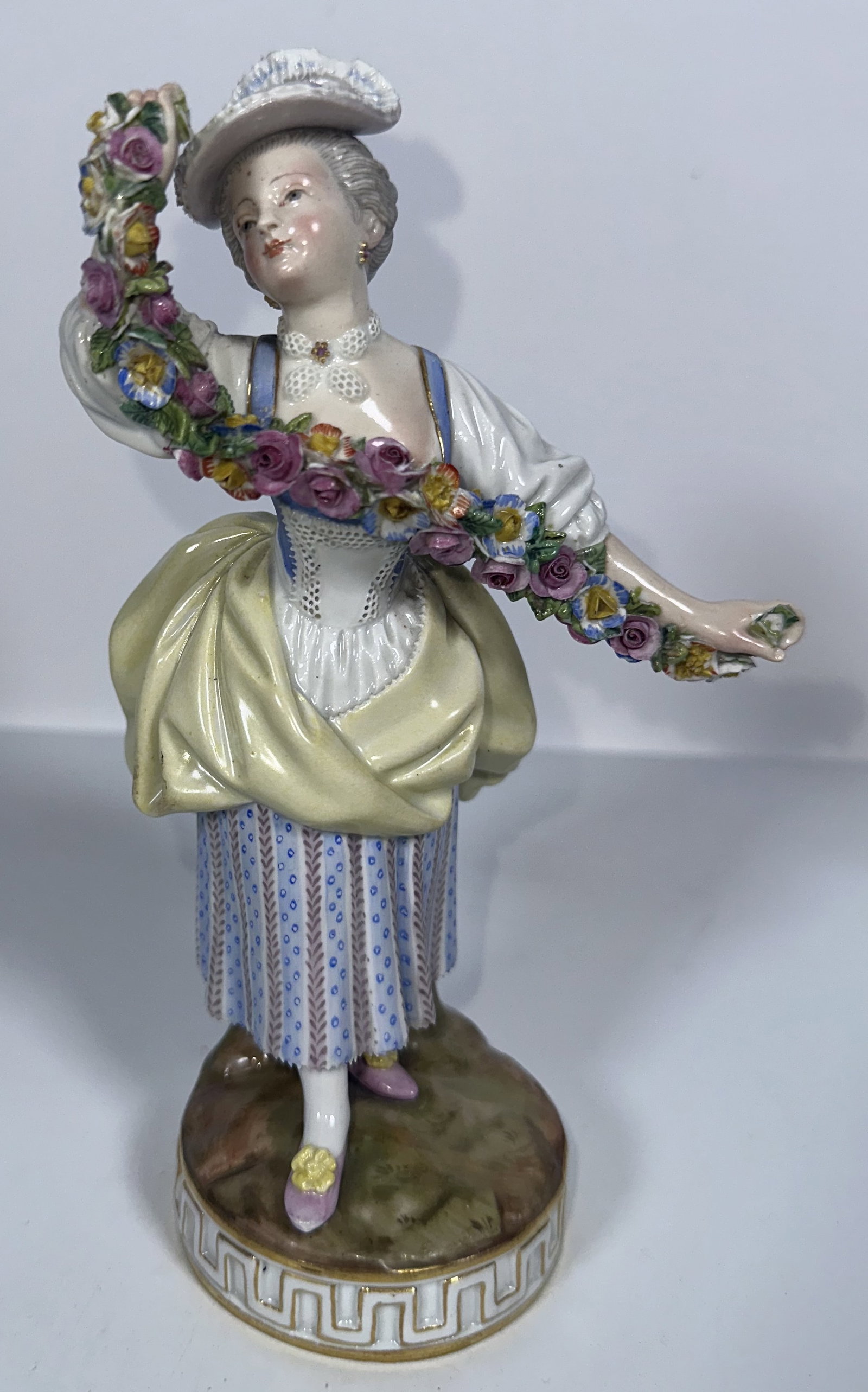 Meissen Porcelain Figure Woman with Garland: Meissen Porcelain Figure Woman with Garland his antique German porcelain figurine is a hand-painted Meissen lady gardener holding a colorful floral garland, designed in the 19th century after Michel V