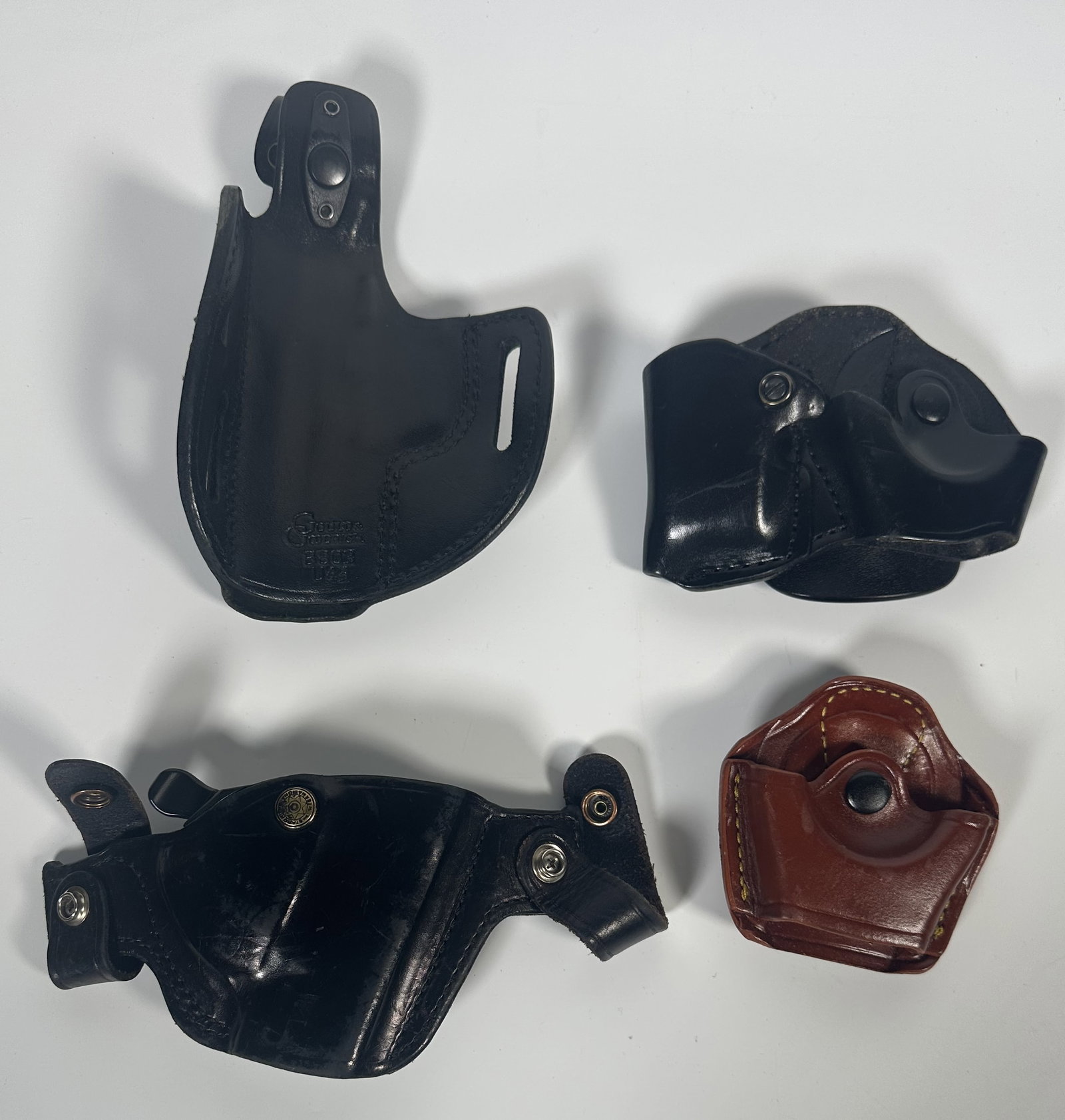 Four Formed Leather Belt Clips, Holster: Formed Leather Belt Clips, Holster Group of four formed leather belt pieces including holsters. Fine quality pieces. For this lot shipping can be done one of two ways: In-House Shipping - A Shipping