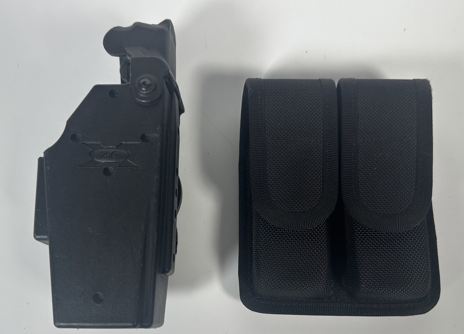 BlackHawk Holster and Velcro Belt Clips: BlackHawk Holster and Velcro Belt Clips The image shows tactical gear including a black polymer/carbon-fiber style concealment paddle holster (left) and a Blackhawk Cordura nylon molded double