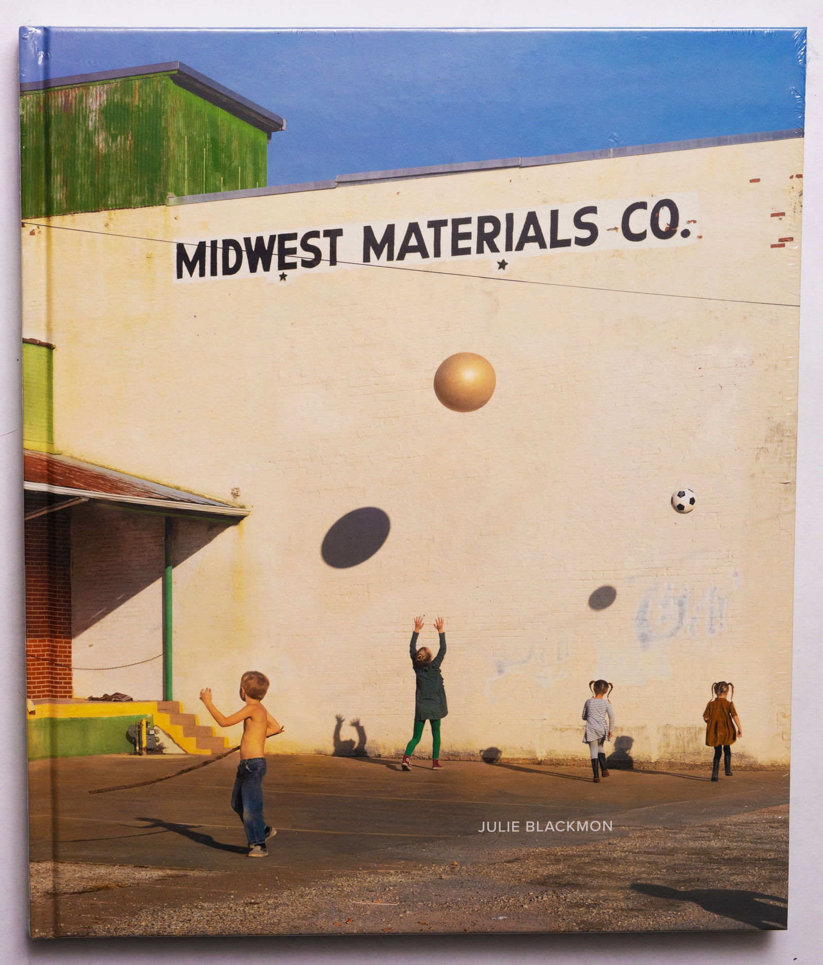 Julie Blackmon, Midwest Materials Co. [SIGNED 2022 1ST EDITION - NEW]: Radius Books, 2022. Hardcover in pictorial boards. First Edition, First Printing. 108 pages with numerous color photographic images throughout. For her third monograph, Midwest Materials, Julie Blackm