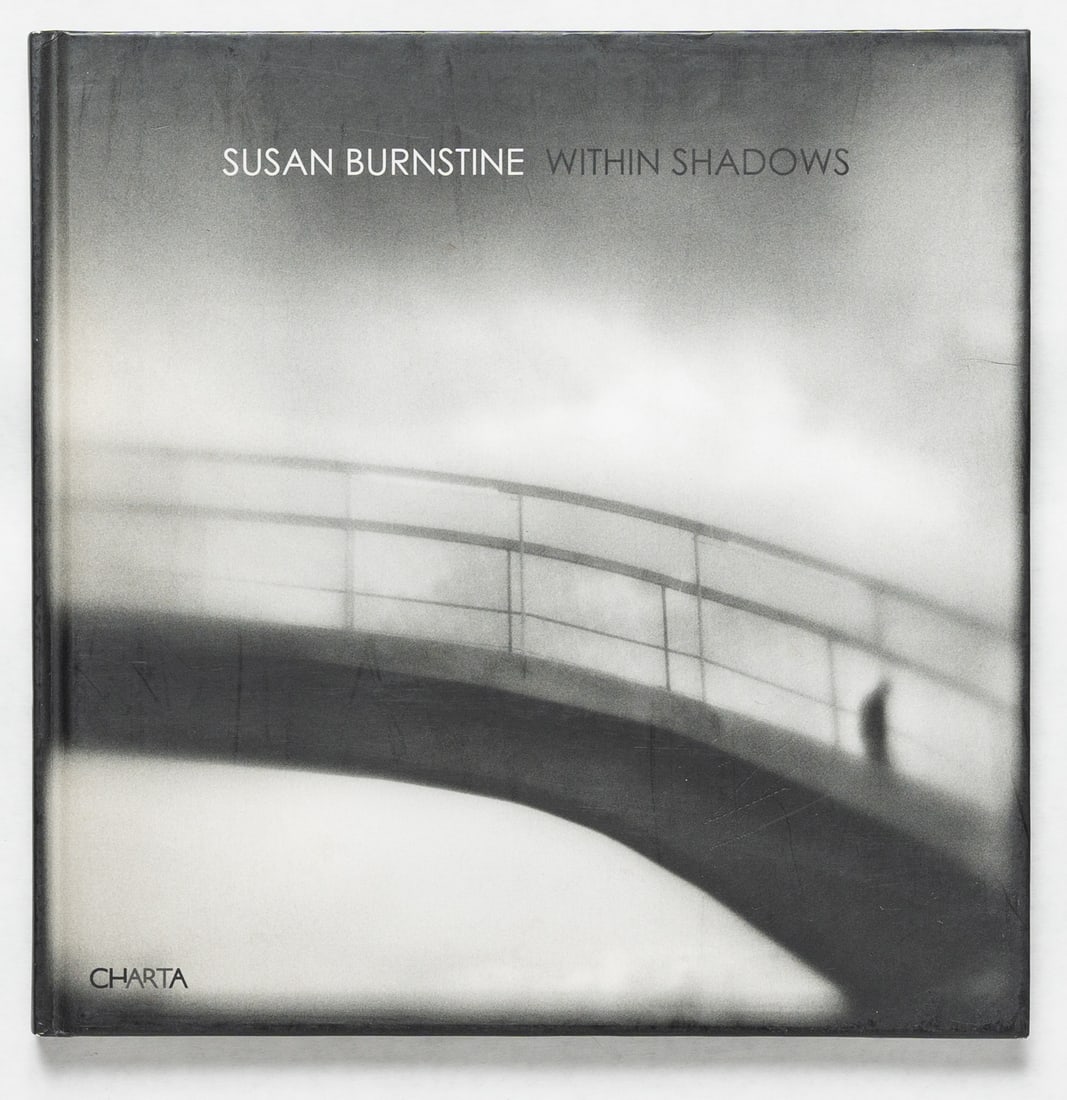 Susan Burnstine Within Shadows [SIGNED 2011 1ST EDITION - FINE]: Charta, 2011, Hardcover in pictorial boards. First Edition, First Printing. 100 pages with numerous black and white images throughout by Susan Burnstine who began photographing with homemade cameras m