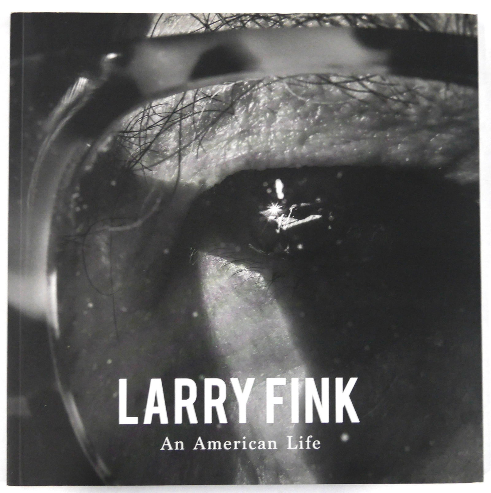 Larry Fink, An American Life [SIGNED - RARE 2016 EXHIBITION CATALOGUE - FINE]: Casa Santa Ana, 2016. Softcover in pictorial wraps. First Edition, First Printing. 9 x 9 inches. 33 pages with 35 black and white photographic images throughout. SIGNED/INSCRIBED and dated 2016 by Lar