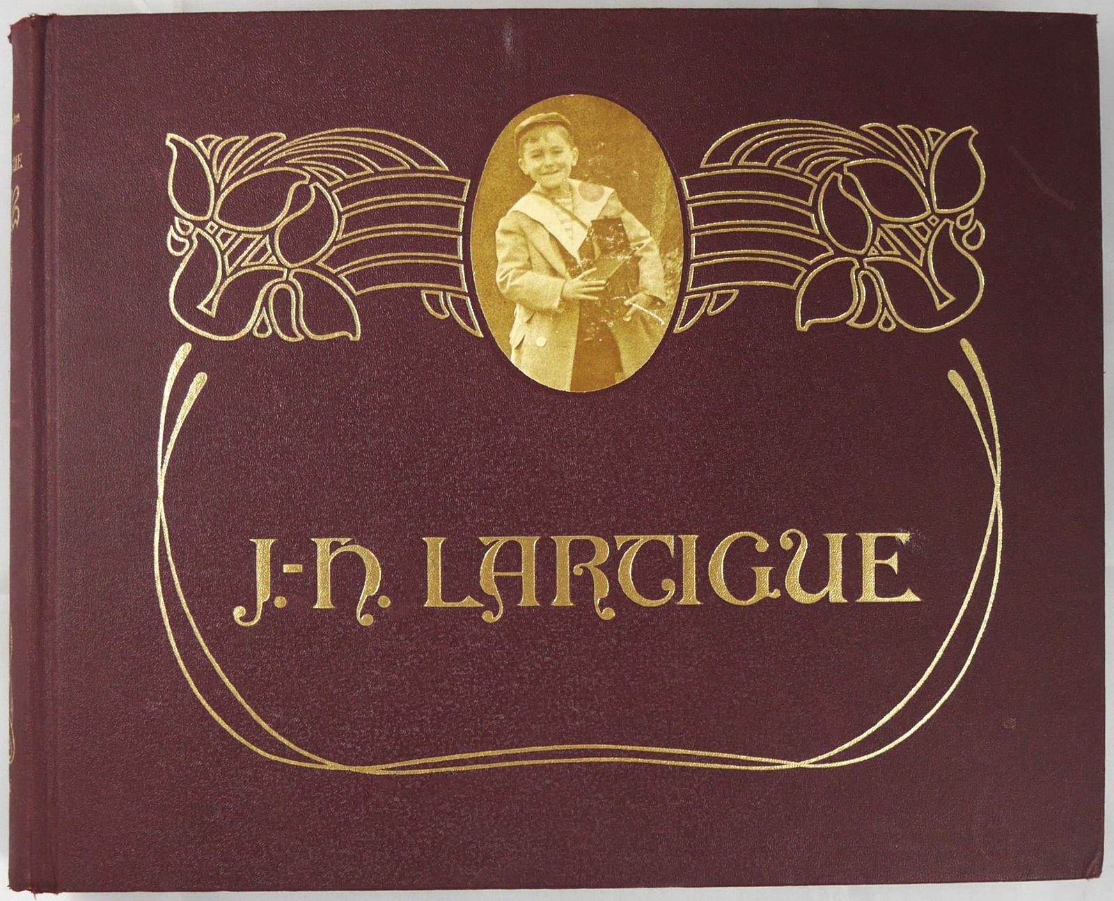 Lartigue, Jacques-Henri; Boyhood Photos [1966 1ST EDITION & 1ST PRINTING]: Lausanne, Switzerland: Ami Guichard 1966. Hardcover. First edition, first printing. Burgundy laminated cloth-covered boards with tipped-in sepia plate, gilded title and foliate design on cover and spi