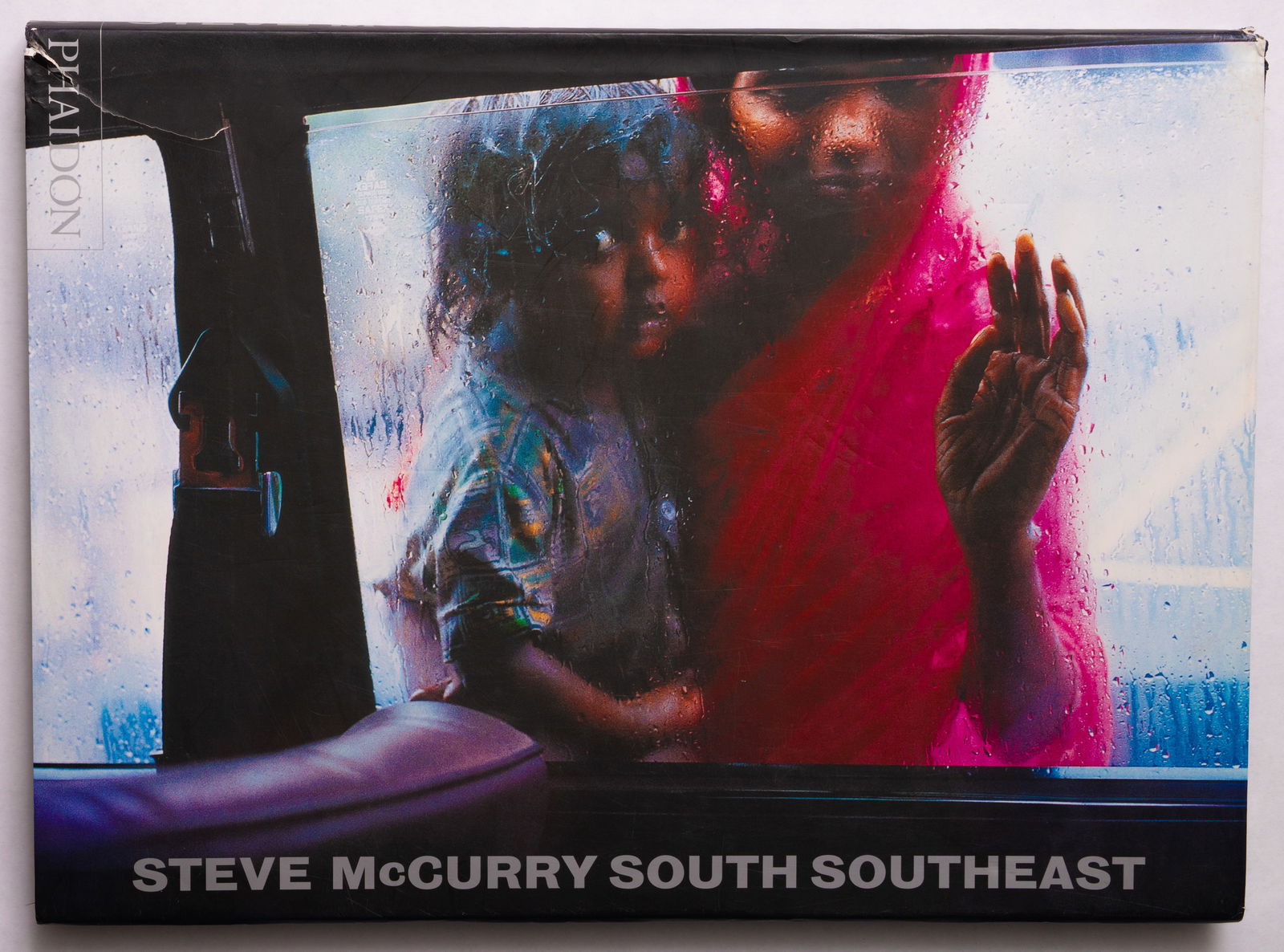 Steve McCurry South Southeast [SIGNED - 2000 1ST EDITION]: Phaidon, 2000. Hardcover in pictorial dust jacket. First Edition, Later Printing. 160 pages with 70 large color photographic images throughout. SIGNED/INSCRIBED by Steve McCurry on the half title page