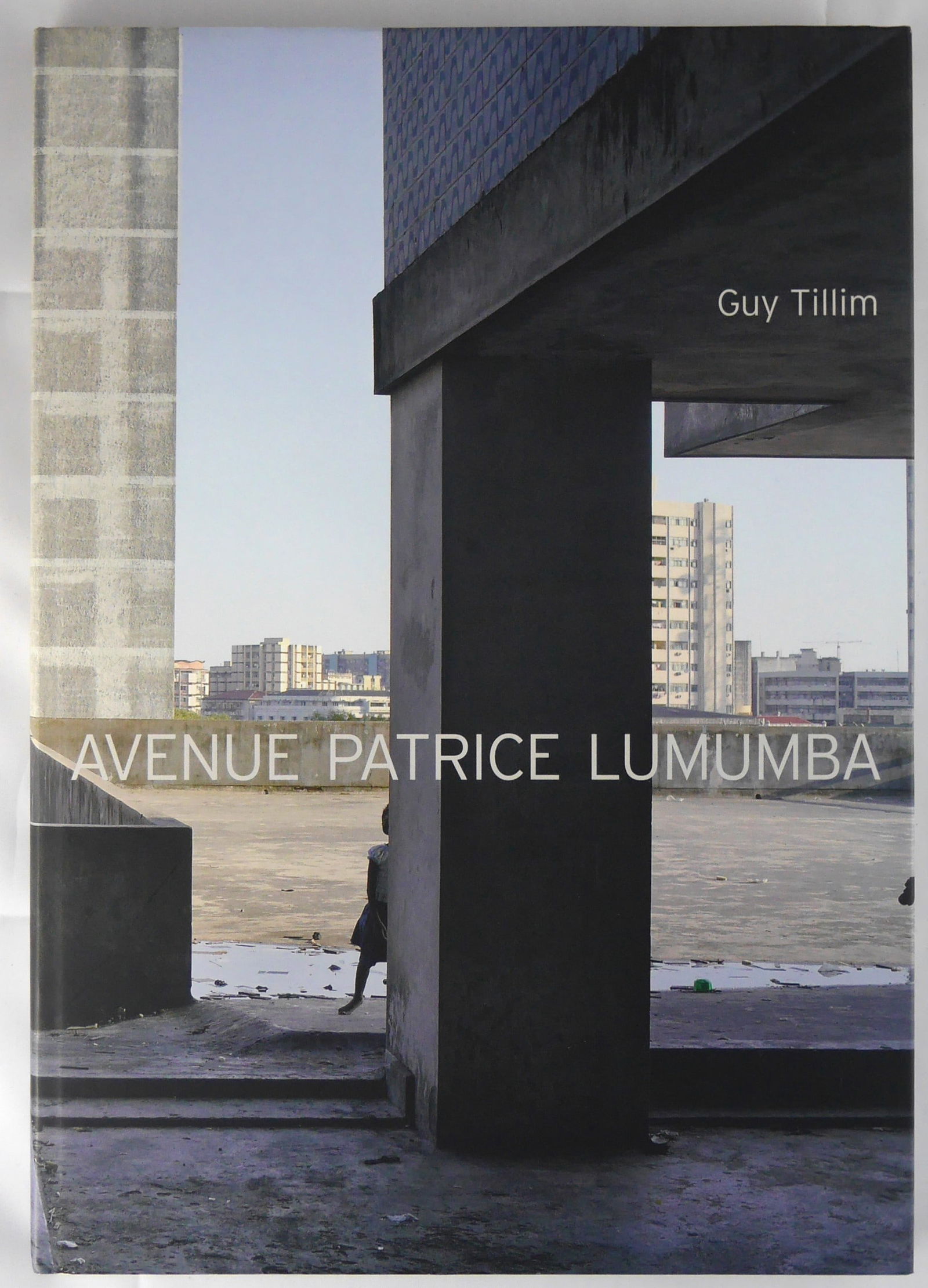 Tillim, Guy; Avenue Patrice Lumumba [SIGNED - 2008 1ST ED 1ST PRINT]: SIGNED COPY Prestel, 2008. Hardcover in pictorial boards. First Edition, First Printing. 60 pages in leporello fold-out format with 27 color photographic images by Guy Tillim. 6-1/4x8-1/2". SIGNED