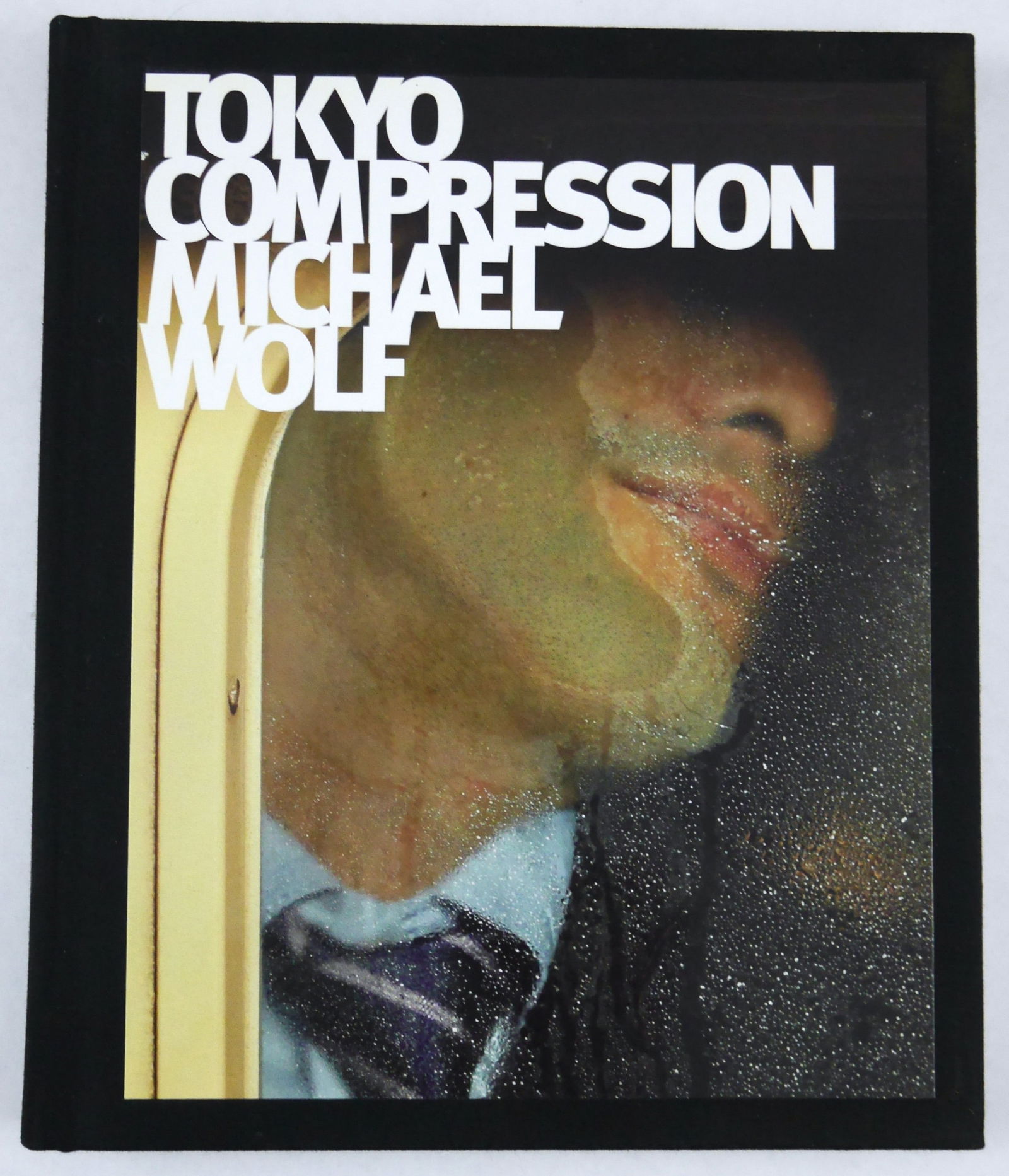 Wolf, Michael; Tokyo Compression [2010 1ST EDITION & 1ST PRINTING]: Peperoni Books and Asia One, 2010. Hardcover wtih tipped in image to front cover. First Edition, First Printing. 112 pages with 75 photographic images in color throughout. Tokyo Compression captures a
