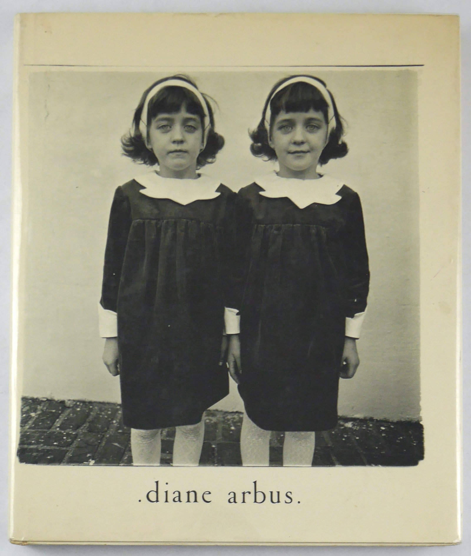 Diane Arbus: An Aperture Monograph [RARE 1ST ED, 2ND PRINT WITH 2 GIRLS IN IDENTICAL RAINCOATS]: Aperture, New York, 1972. Hardcover in pictorial dust jacket. First Edition, Second Printing (stated) with the "Two Girls in Identical Raincoats" image that was struck from all but a few copies of the