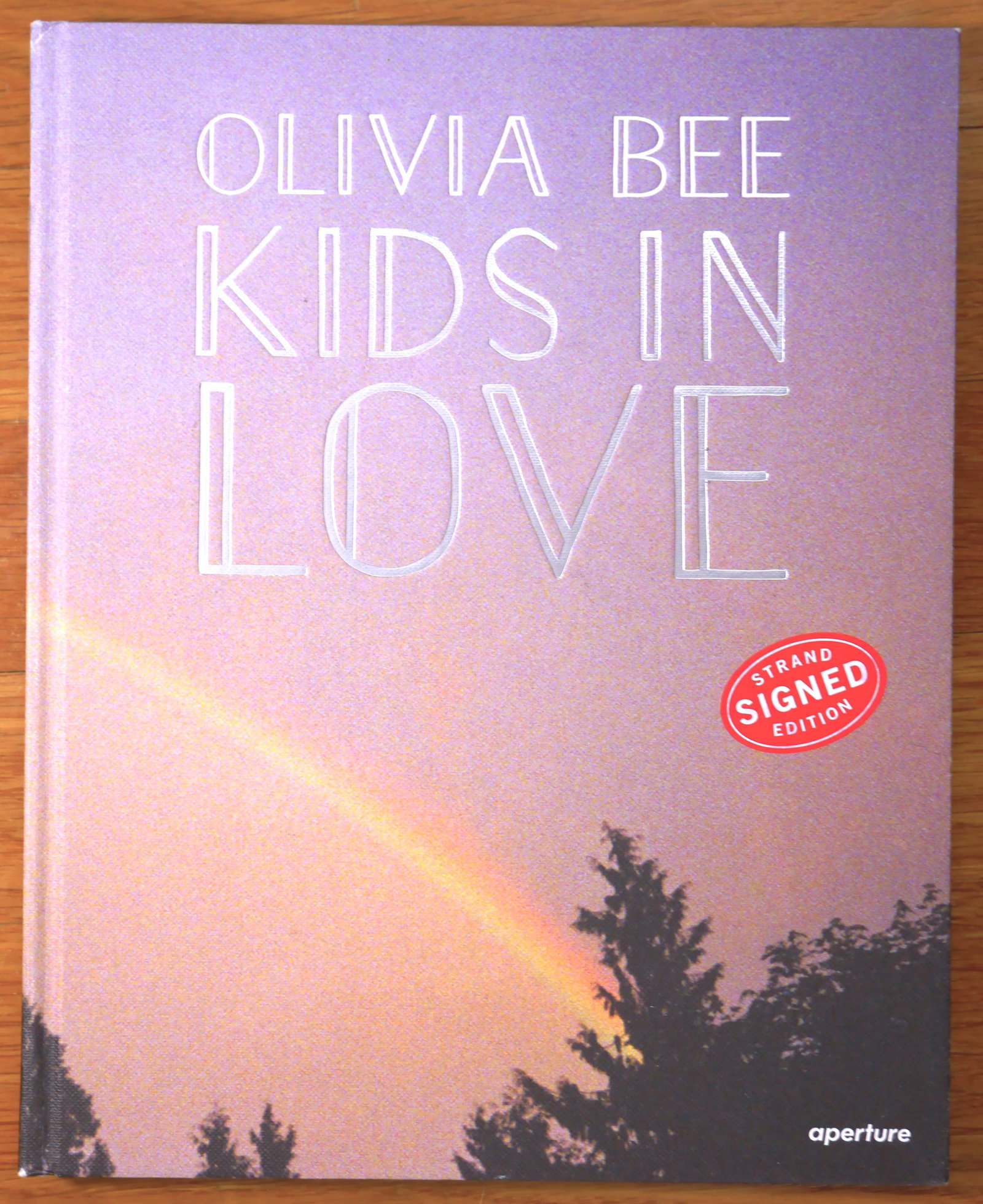 Bee, Olivia; Kids In Love [SIGNED - 1ST EDITION & 1ST PRINTING - FINE COPY]: SIGNED COPY Aperture, New York, 2016. Hardcover in pictorial boards. First Edition, First Printing. 8 x 10 in. 136 pages, 75 four-color and black-and-white images. SIGNED by Olivia Bee on the title pa