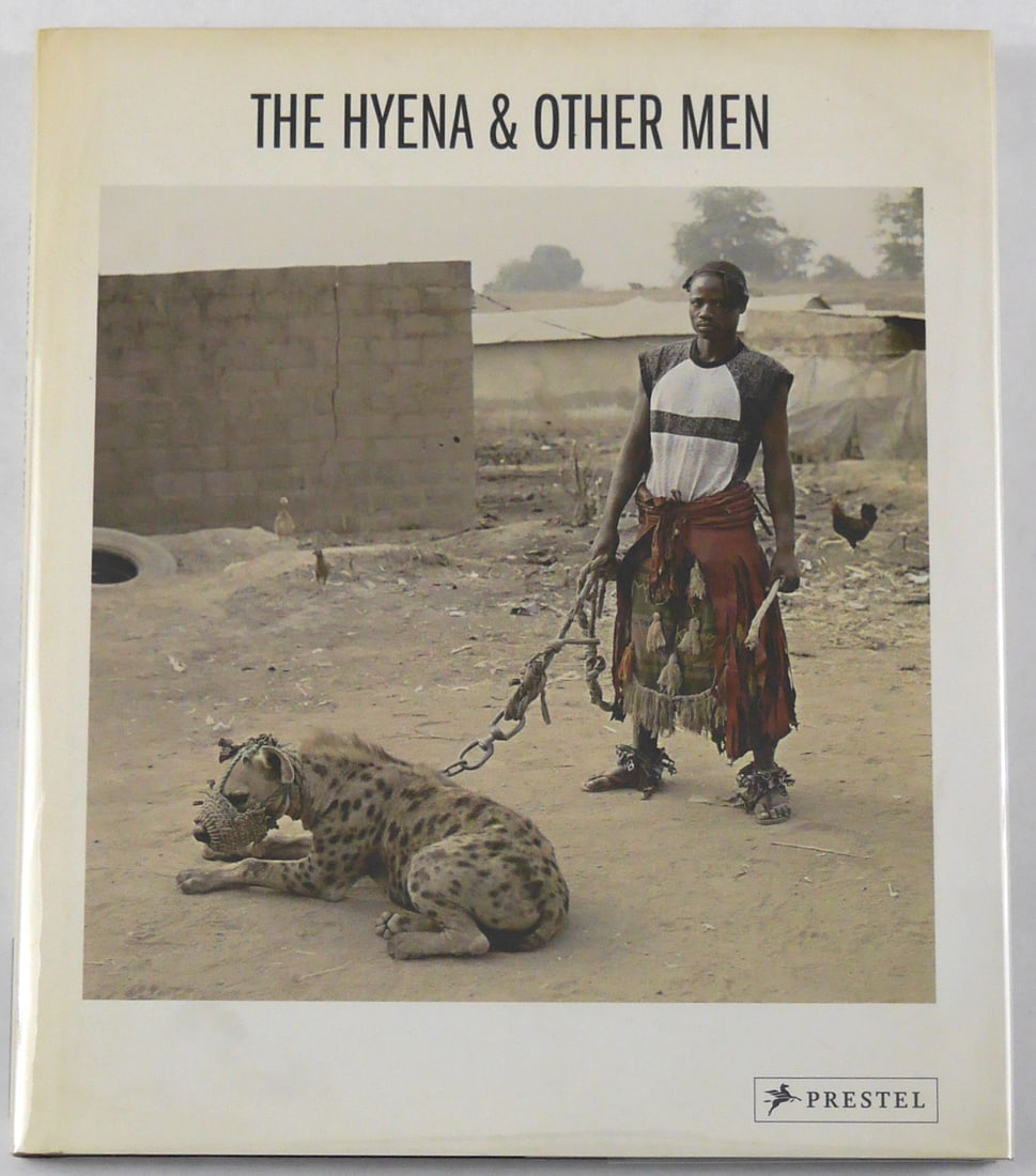 Pieter Hugo, The Hyena and Other Men [SIGNED 2007 1ST EDITION 1ST PRINTING]: Book Description: Prestel. Munich, Berlin, London, New York. 2007. Hardcover in pictorial dust jacket. First edition, first printing. 80 pages with 35 color photographs by Pieter Hugo. Introduction by