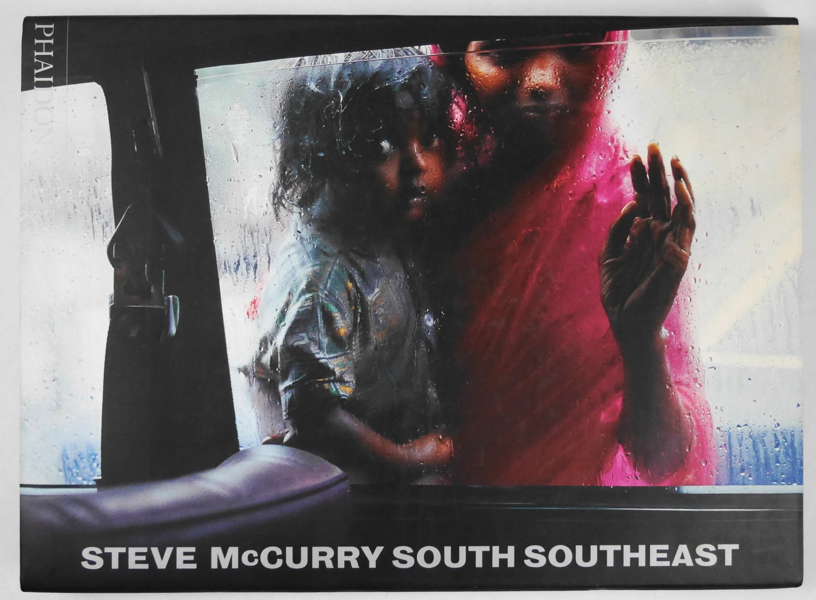 Steve McCurry South Southeast [SIGNED - 2000 1ST EDITION]: Phaidon, 2000. Hardcover in pictorial dust jacket. First Edition, Later Printing. 160 pages with 70 large color photographic images throughout. SIGtED/INSCRIBED by Steve McCurry: "To Nick and Nanette 