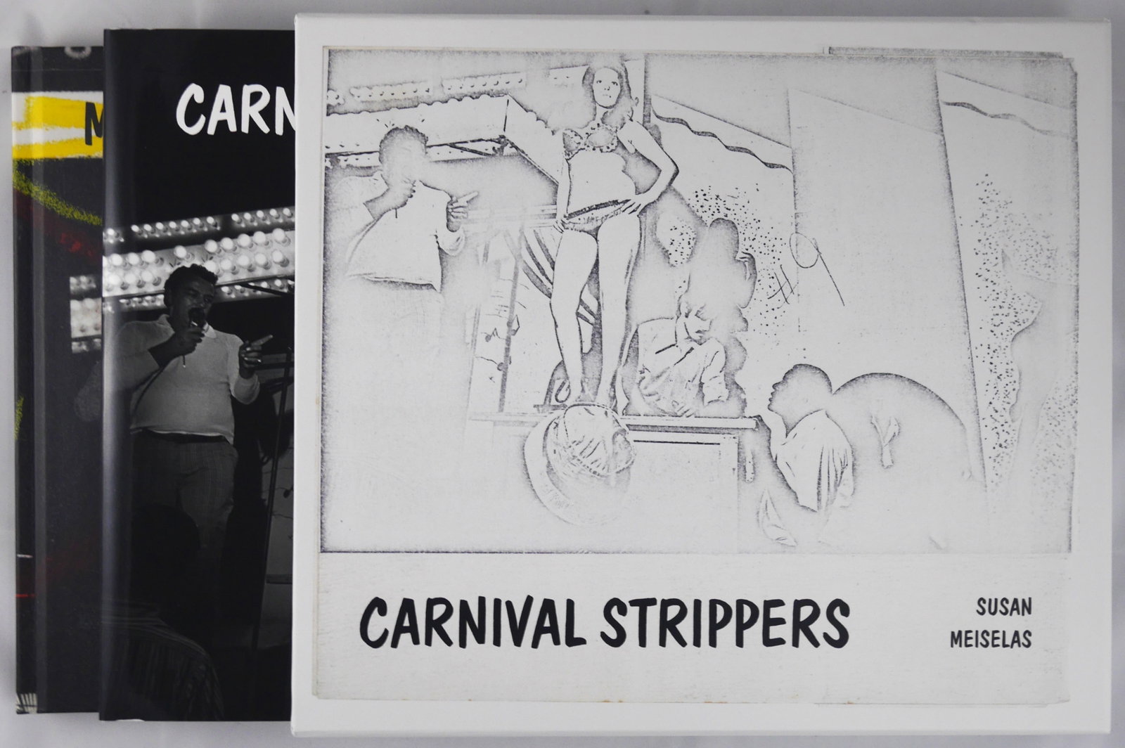 Meiselas,Susan; Carnival Strippers Revisited [SIGNED x 2 - 2022 1ST ED & 1ST PRINT 2 VOLS SLIPCASE]: Steidl, 2022. 2 hardcover volumes (1 with dust jacket and 1 in pictorial boards) housed in a printed cardboard slipcase. First Edition, First Printing. 27.5 x 23.5 cm. Photographs by Susan Meiselas. T